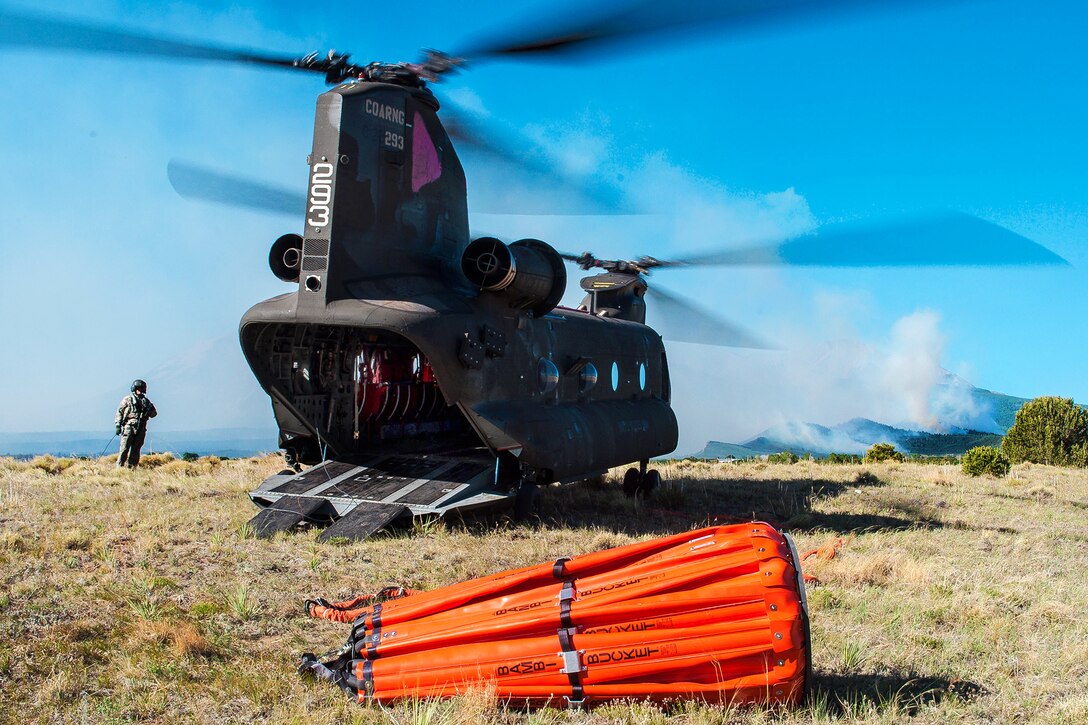 Soldiers prepare a CH-47 Chinook helicopter equipped with a Bambi bucket to help fight the East Peak fire near La Veta, Colo., June 21, 2013. The soldiers, National Guardsmen, are assigned to the Colorado Army National Guard's 2nd Battalion, 135th Aviation Regiment, stationed on Buckley Air Force Base, Aurora, Colo.
