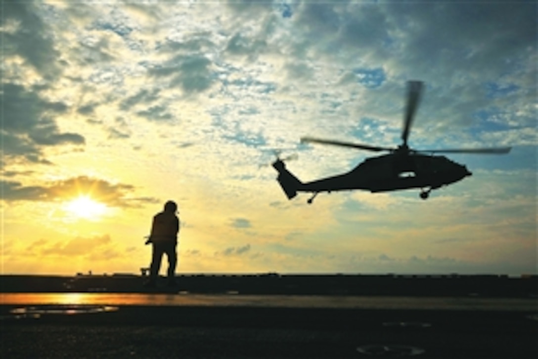 Navy Chief Petty Officer Jonard Sygaco monitors the departure of an MH-60S Sea Hawk helicopter from the flight deck of the USS George Washington in the Pacific Ocean, June 23, 2013. The George Washington and its embarked air wing, Carrier Air Wing 5, provide a combat-ready force that protects and defends the collective maritime interest of the U.S. and its allies and partners in the Indo-Asia-Pacific region. 

