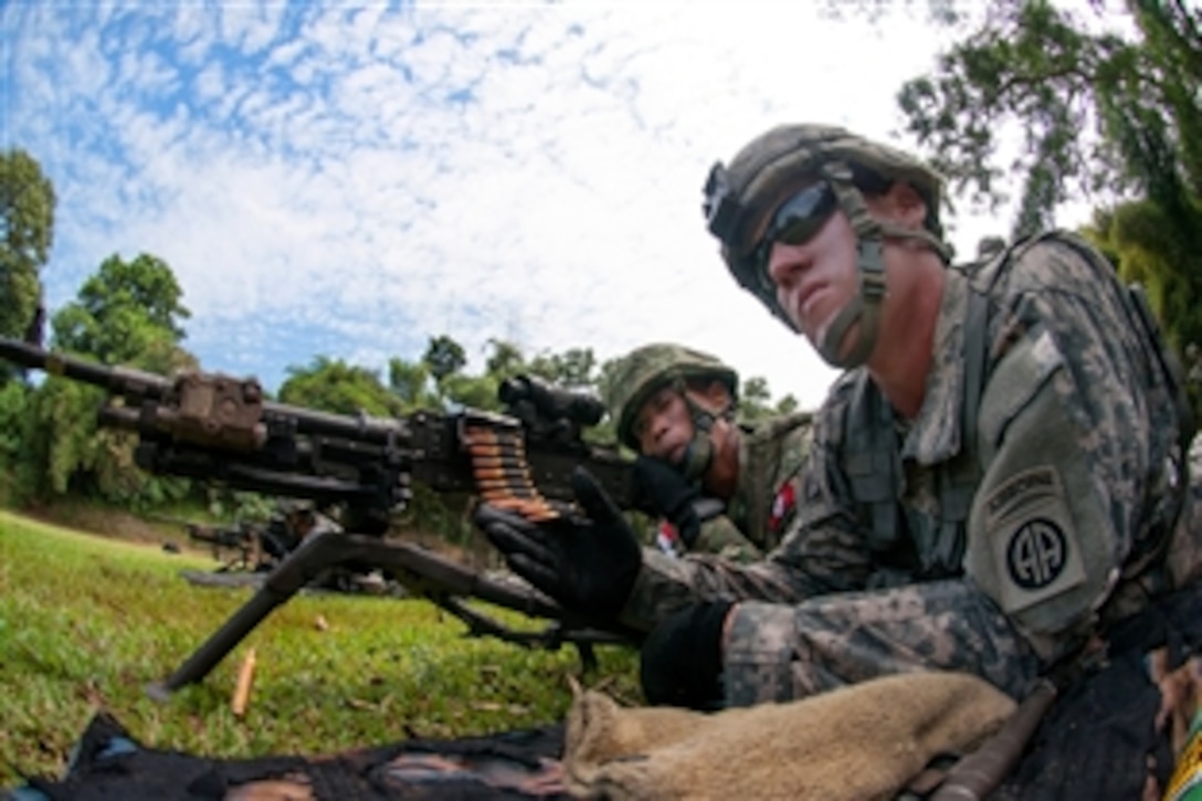 A U.S. paratrooper, right, helps an Indonesian army paratrooper prepare to fire an M240B machine gun during weapons training as part of exercise Garuda Shield 2013 at 1st Kostrad headquarters in West Java, Indonesia, June 14, 2013. 