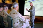 Air Force Maj. Gen. Jim Graves, the assistant to the Chairman of the Joint Chiefs of Staff for Reserve Affairs, gives a slideshow presentation to National Guard and Reserve members at U.S. Naval Station Guantanamo Bay, Dec. 10. Graves spoke on the importance of joint service experience within the military as well as joint service rank advancement aspects specific to reserve component troops.