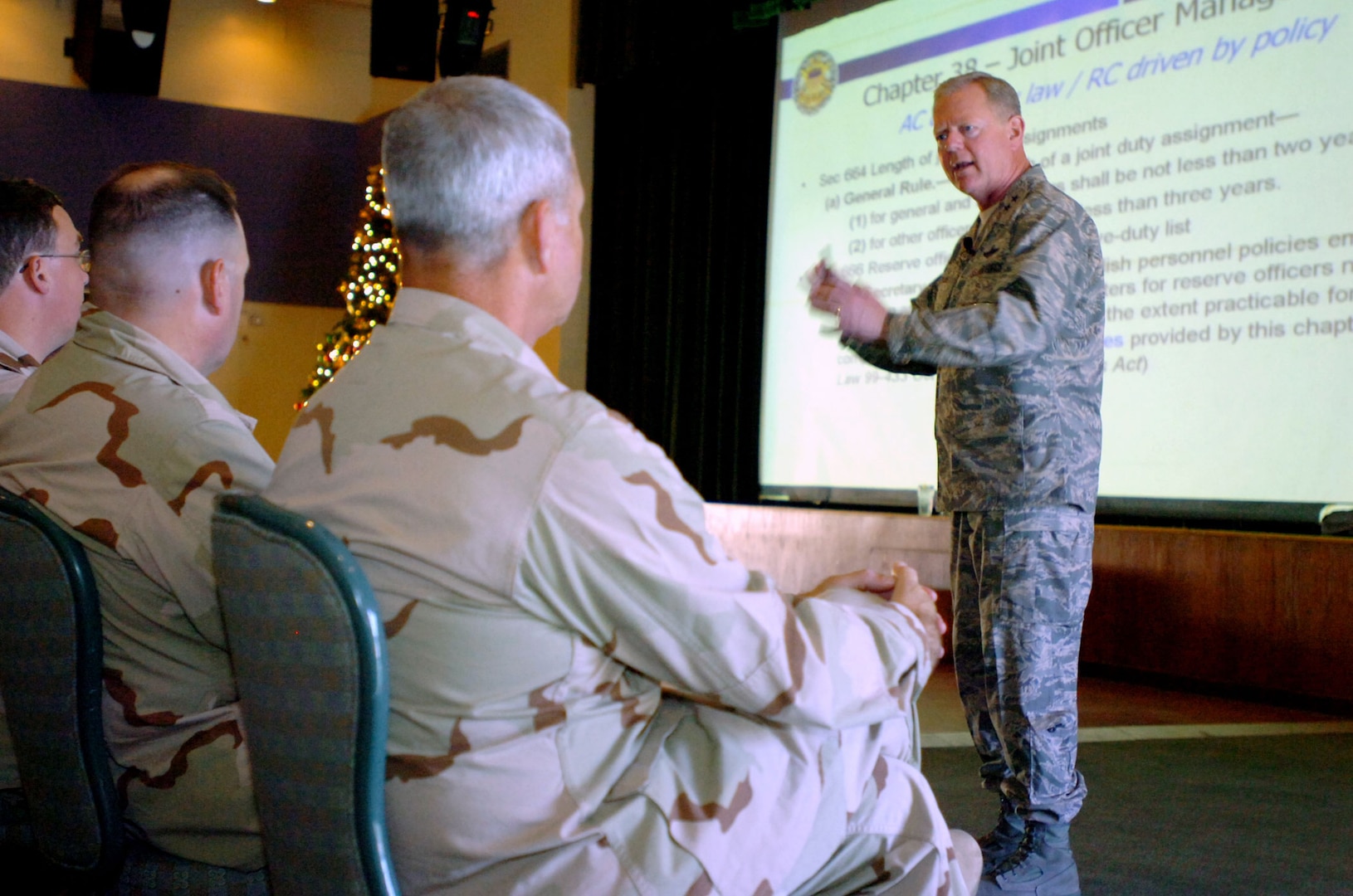 Air Force Maj. Gen. Jim Graves, the assistant to the Chairman of the Joint Chiefs of Staff for Reserve Affairs, gives a slideshow presentation to National Guard and Reserve members at U.S. Naval Station Guantanamo Bay, Dec. 10. Graves spoke on the importance of joint service experience within the military as well as joint service rank advancement aspects specific to reserve component troops.