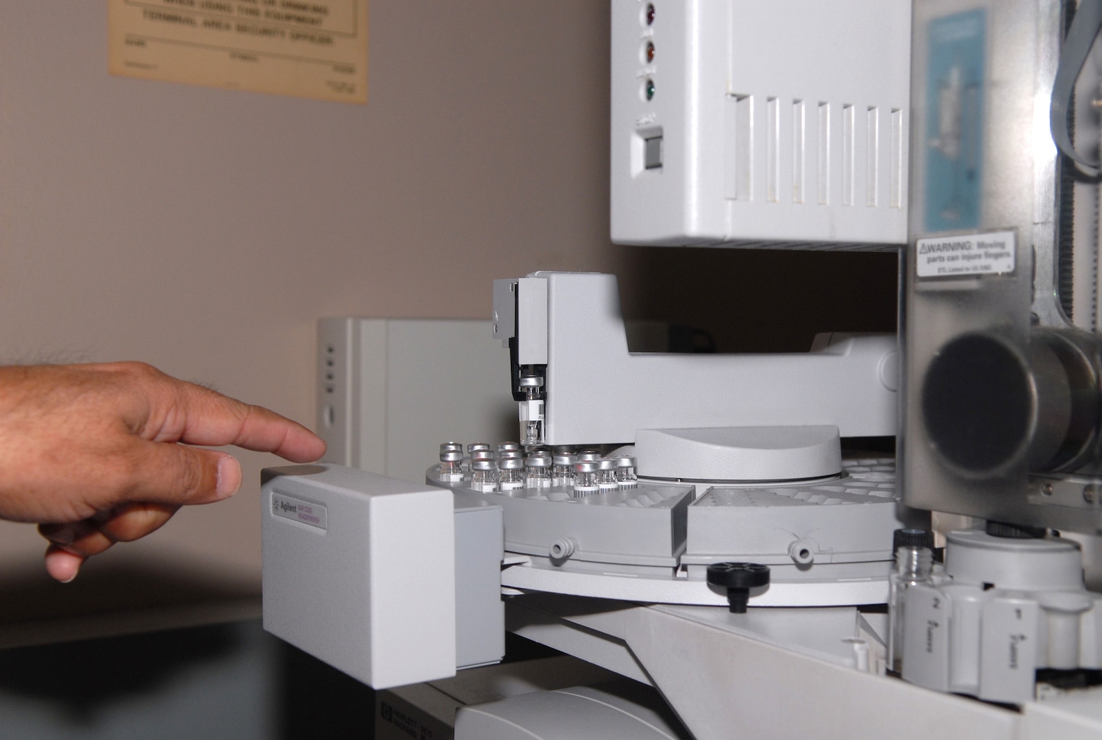 A lab specialist at the military drug testing facility in Texas points out samples prepared for analysis with a gas chromatograph/mass spectrometer. The military laboratory's high-tech equipment can find and identify any drugs present.