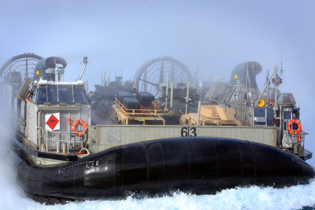 A Navy Landing Craft Air Cushion arrives aboard the USS Boxer loaded with 13th Marine Expeditionary Unit cargo and military vehicles during PHIBRON MEU Integrated Training June 10, 2013.  PMINT is a three week long pre-deployment training event focusing on the combined Marine Expeditionary Unit and Amphibious Ready Group capabilities and the strengthening of the Navy and Marine Corps team.