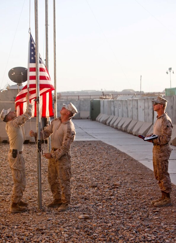 Sgt. Maj. Timothy Rudd, the battalion sergeant major of 2nd Battalion, 8th Marine Regiment, Regimental Combat Team 7, watches as Sgt. Erik Lueres and Cpl. David Jewell, clerks with Headquarters and Service Company, retire a flag here, June 16, 2013.  "I have flag ceremonies almost every day," said Jewell, from Philadelphia. "But the sergeant major is the first person who has actually come to personally raise his own flag."