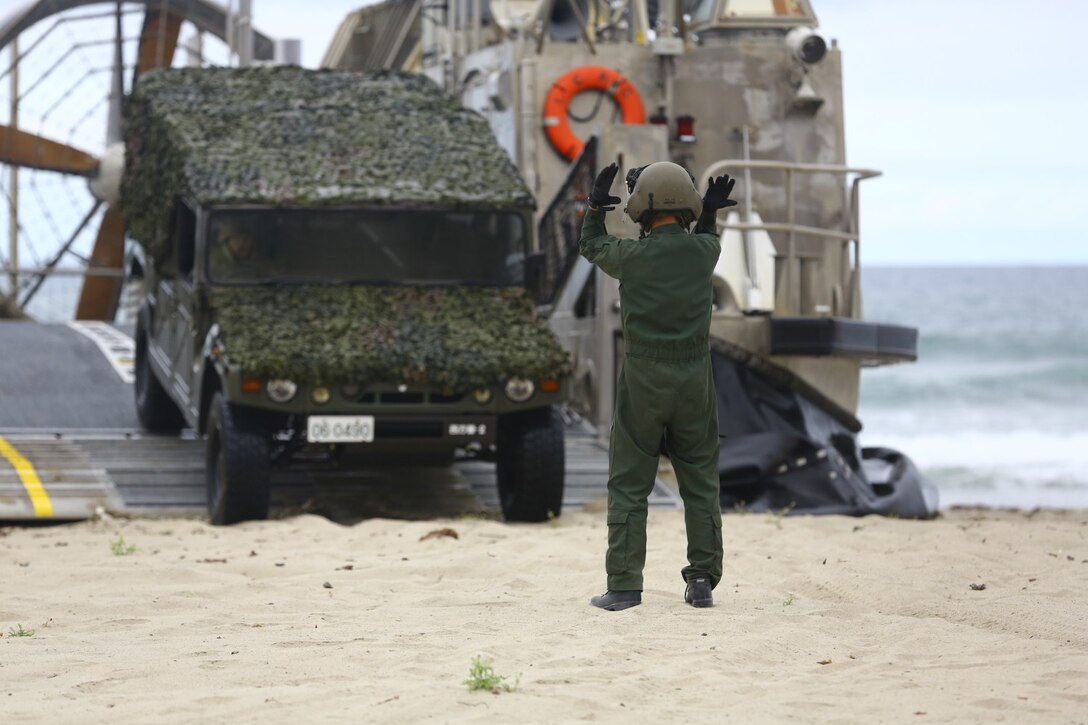A member of the  Japanese Self Defense Force directs a vehicle during an offload on Red beach here. U.S., Japanese and coalition forces performed a joint exercise with coordinated offloads and beach landing scenarios as part of exercise Dawn Blitz. Dawn Blitz 2013 is a multinational amphibious exercise off the Southern California coast that refocuses Navy and Marine Corps and coalition forces in their ability to conduct complex amphibious operations essential for global crisis response across the range of military operations. (Photo by: U.S. Marine Corps Cpl. Jonathan R. Waldman, Combat Camera, 11TH Marine Expeditionary Unit)