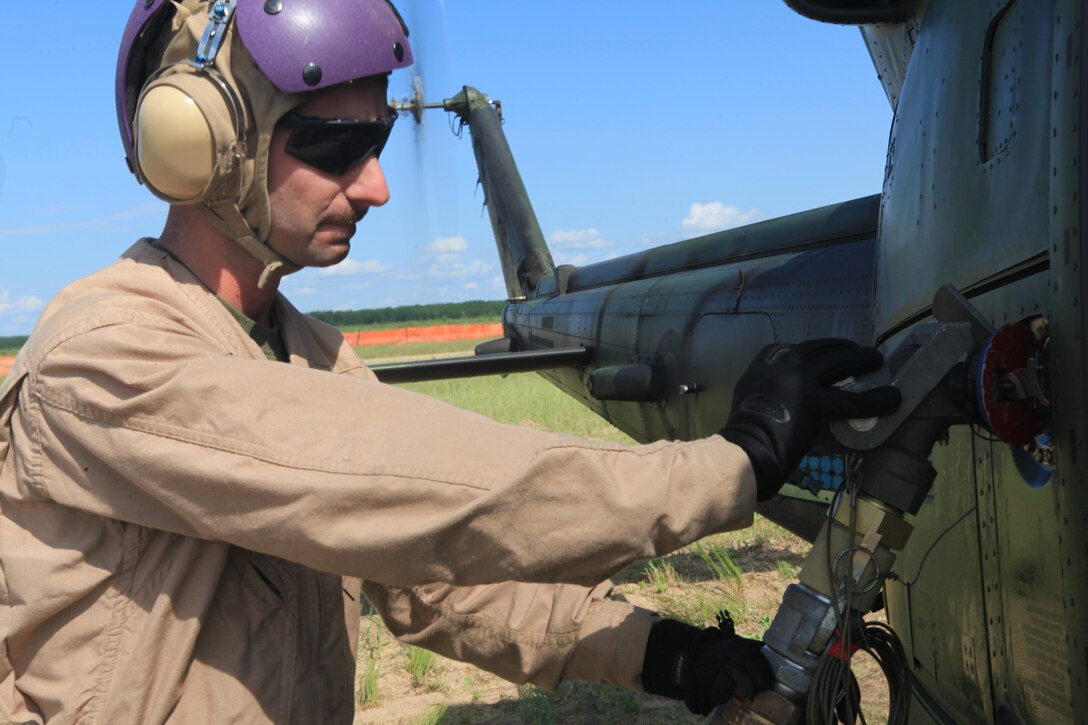 Sgt. Ryan Ott, a fuel technician with Marine Wing Support Squadron 471 and a Minnesota native, refuels a Canadian UH-1N Huey helicopter at a forward refueling point at Exercise Maple Flag 46 here, June 18. Maple Flag is an annual, multinational, air-combat training exercise that trains participating forces together as large coalition forces. (U.S. Marine Corps photo by Lance Cpl. Tiffany Edwards/Released)