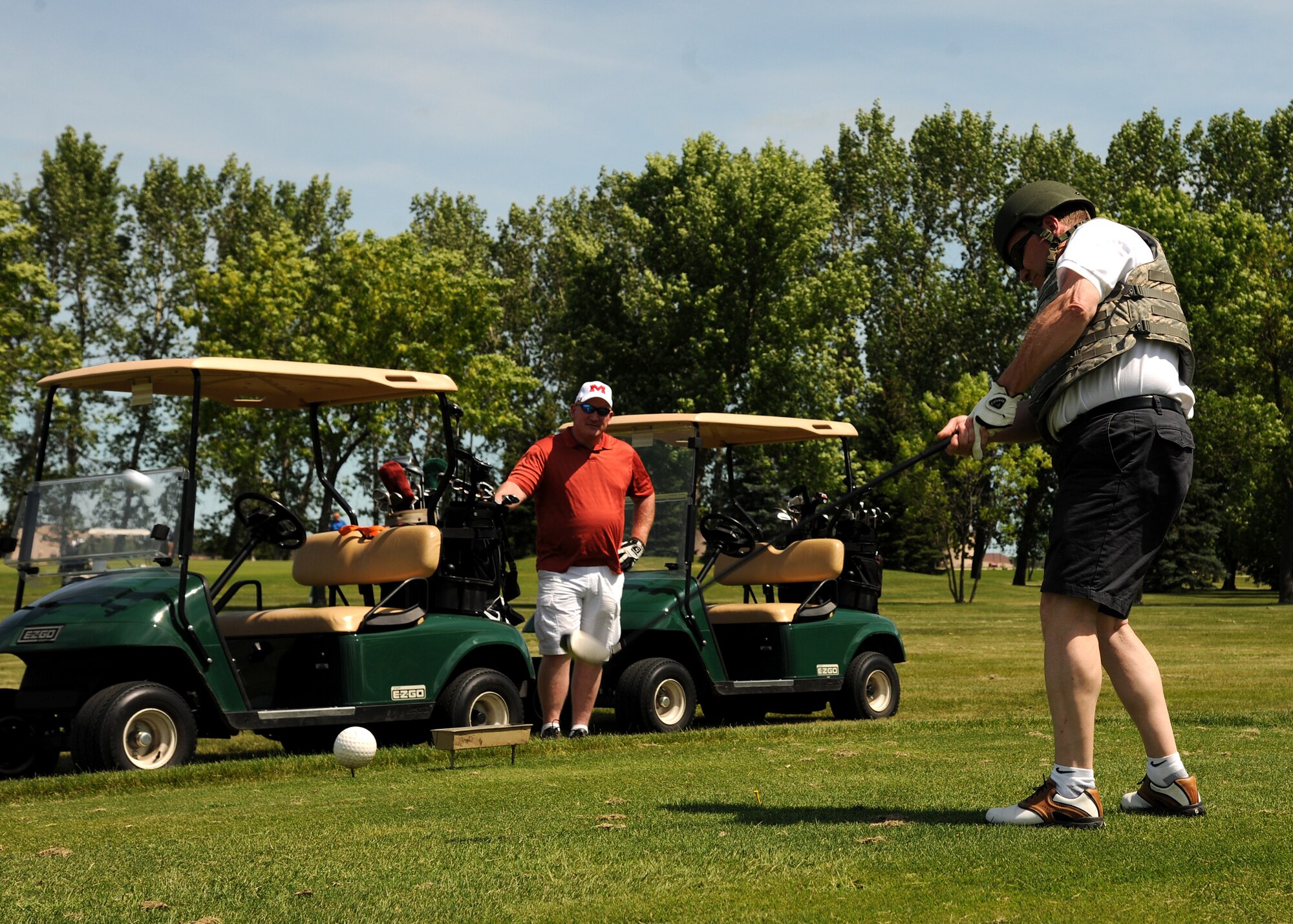 Don Fisk, Honorary Ambassador No. 6 to Grand Forks Air Force Base, N.D., golfs while wearing a flak jacket and helmet during the annual Military Affairs Committee Golf Tournament on June 24, 2013, at the base’s Plainsview Golf Course.  During the MAC Golf Tournament, some of the course holes come with challenges to make the game more interesting, such as a longest drive, longest putt, and te straightest drive. (U.S. Air Force photo/Airman 1st Class Ashley Nicole Taylor)