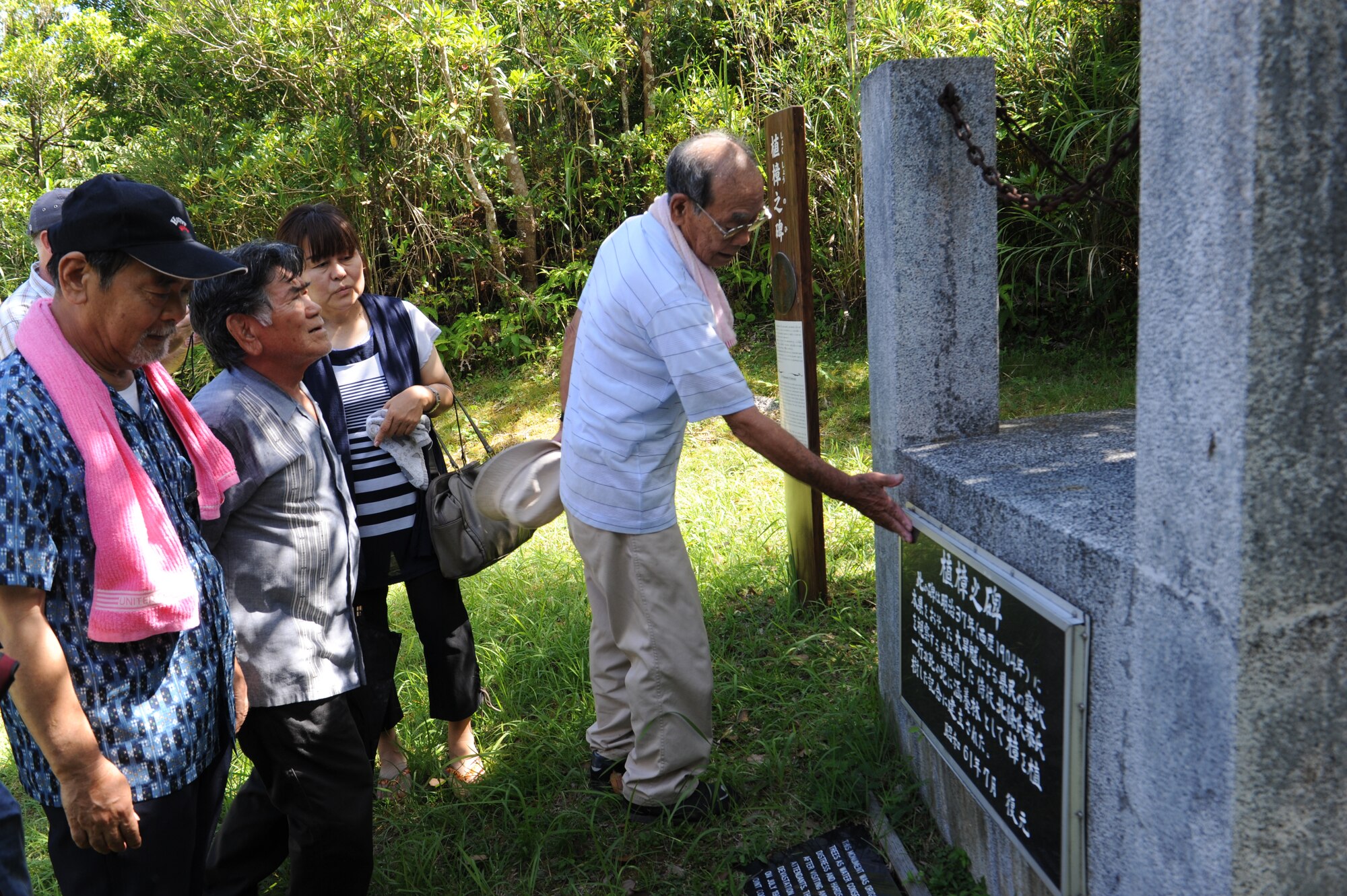 Local Japanese community members look at a monument during a sacred site tour on Kadena Air Base, Japan, June 22, 2013. The monument was built to commemorate the planting of camphor trees after a great drought in 1904. (U.S. Air Force photo by Airman 1st Class Malia Jenkins/Released)