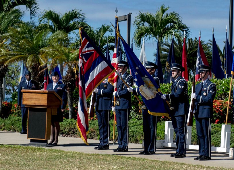 Members of the 15th Wing Honor Guard present arms before the singing of the national anthem at the 15th Operations Group change of command ceremony at the Missing Man Formation on Joint Base Pearl Harbor-Hickam, Hawaii, June 21, 2013. During the ceremony, Col. Michael Merritt assumed command from Col. Dan Baldessari. (U.S. Air Force Photo/Staff Sgt. Terri Paden)