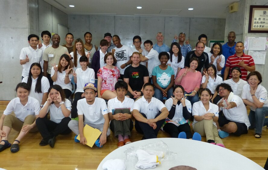 Kadena Language Institute students and 18th Wing volunteers pose for a group photo after walking and cleaning the neighborhood in Kadena Town, Japan, June 21, 2013. The main purpose of the event was to help the local students improve their English skills. It also aimed to deepen friendships and mutual understandings between the students and military volunteers through language, culture and activities in the programs.  (Courtesy photo)