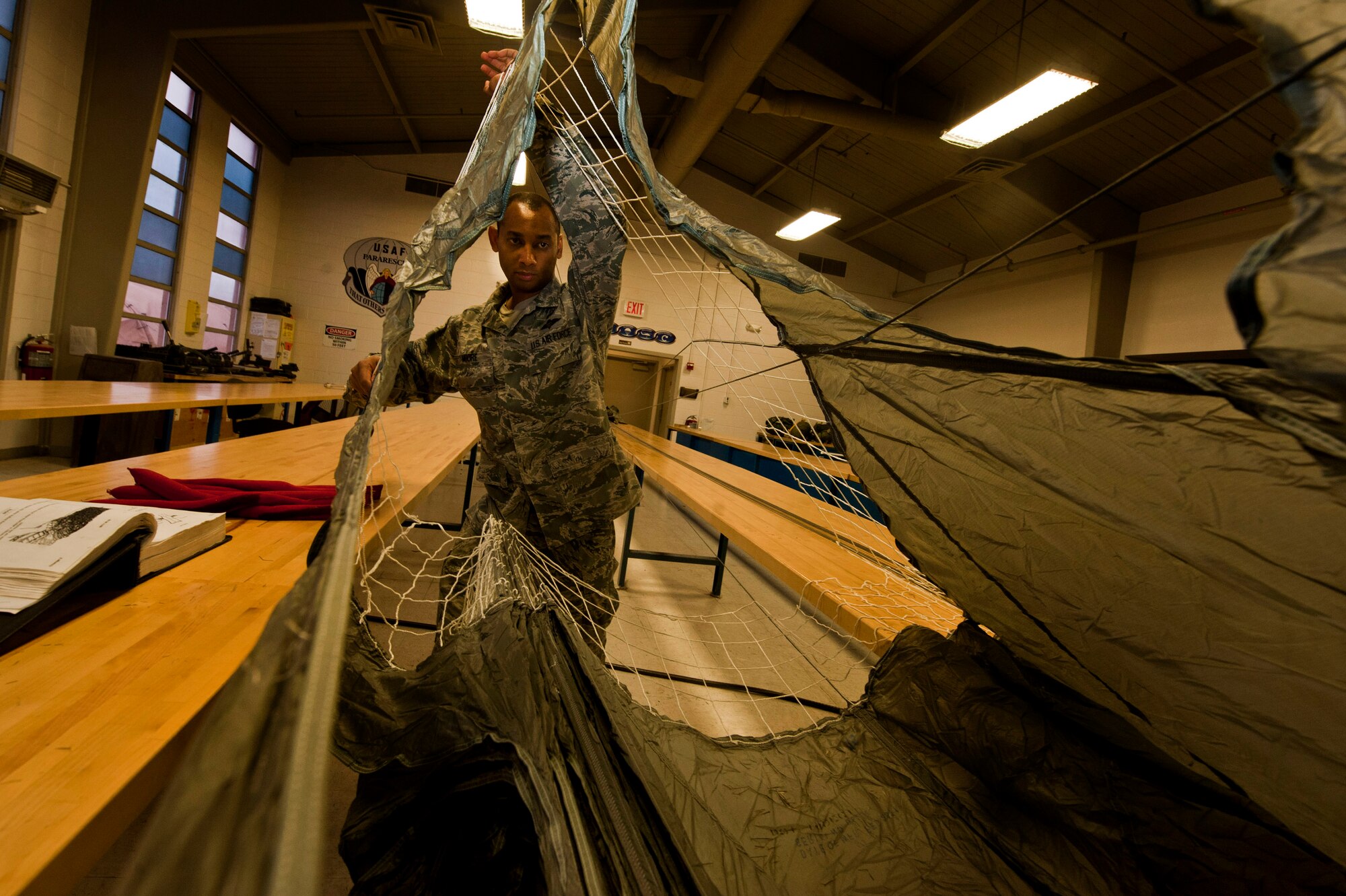 U.S. Air Force Staff Sgt. Shamir Moore, 58th Rescue Squadron aircrew flight equipment technician, cleans and inspects a MC1-1D parachute June 24, 2013, at Nellis Air Force Base, Nev. After ensuring the parachute is clean and functional, it will be repacked and used again. (U.S. Air Force photo by Senior Airman Daniel Hughes) 