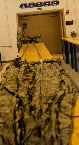 U.S. Air Force Staff Sgt. Shamir Moore, 58th Rescue Squadron aircrew flight equipment technician, checks the pack that will hold a MC1-1D parachute June 24, 2013, at Nellis Air Force Base, Nev. The aircrew flight equipment Airmen supports the pararescuemen of the 58th RQS. (U.S. Air Force photo by Senior Airman Daniel Hughes) 