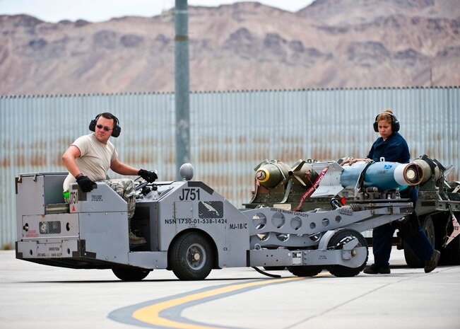 Airman 1st Class James Haddock and Staff Sgt. Lorena Hodge, 4th Aircraft Maintenance Squadron aircraft armament systems technicians, Seymour Johnson Air Force Base, N.C., transport a GBU-20 inert bomb during Green Flag-West 13-5 June 24, 2013, at Nellis Air Force Base, Nev. A typical weapons team consists of one team chief and two weapons loader Airmen. (U.S. Air Force photo/Senior Airman Brett Clashman)