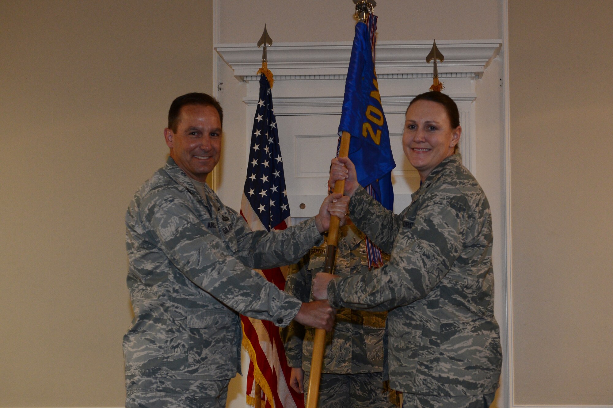 U.S. Air Force Col. Scott Arcuri, 20th Mission Support Group commander, passes the unit guide-on to Lt. Col. Tara White, the  incoming commander for the 20th Force Support Squadron at Shaw Air Force Base, S.C., June 17, 2013. Changes of commands are military tradition that represents the transfer of responsibilities from the presiding officials to the incoming official. (U.S. Air Force photo by Airman 1st Class Krystal M. Jeffers/Released)