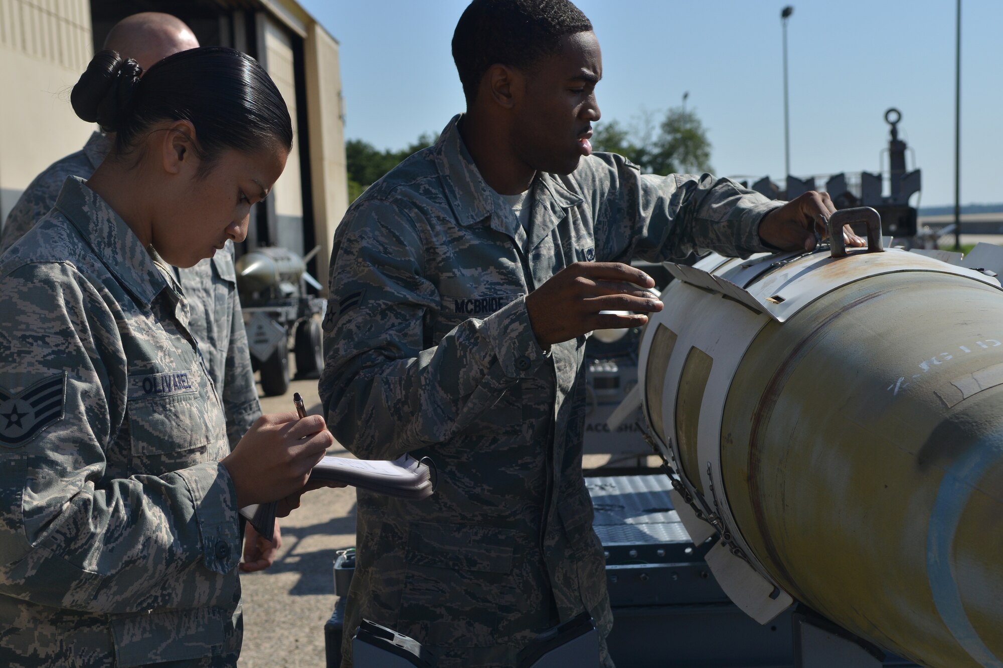 U.S. Air Force Staff Sgt. Charmaine Olivarez and Airman 1st Class Grallian McBride, 20th Aircraft Maintenance Squadron weapons load crew members, go through the steps for weapons loading during the quarterly load crew of the quarter competition, Shaw Air Force Base, S.C., June 21, 2013. The competition consists of crew members from all three fighter squadrons. (U.S. Air Force photo by Airman 1st Class Ashley L. Gardner/Released)