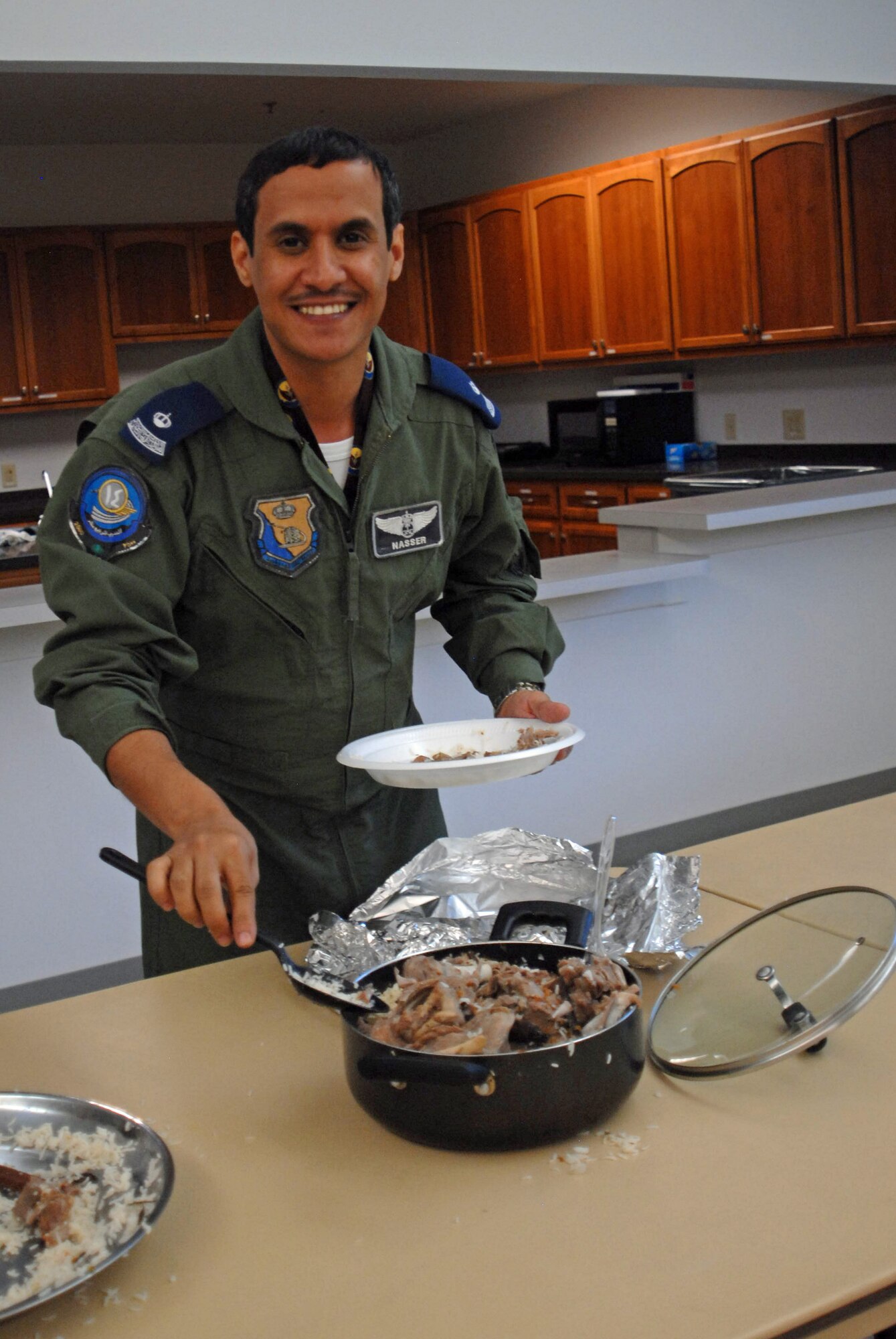 GOODFELLOW AIR FORCE BASE, Texas – An international student from the 315th Training Squadron helps himself to plate of goat kabbash during the International Student Brown Bag Luncheon June 18 at the base chapel.  Team Goodfellow members ate lunch with foreign officers enrolled in the International Officer Intelligence Course to learn about their countries’ customs, foods and military. (U.S. Air Force photo/ Airman 1st Class Breonna Veal)
