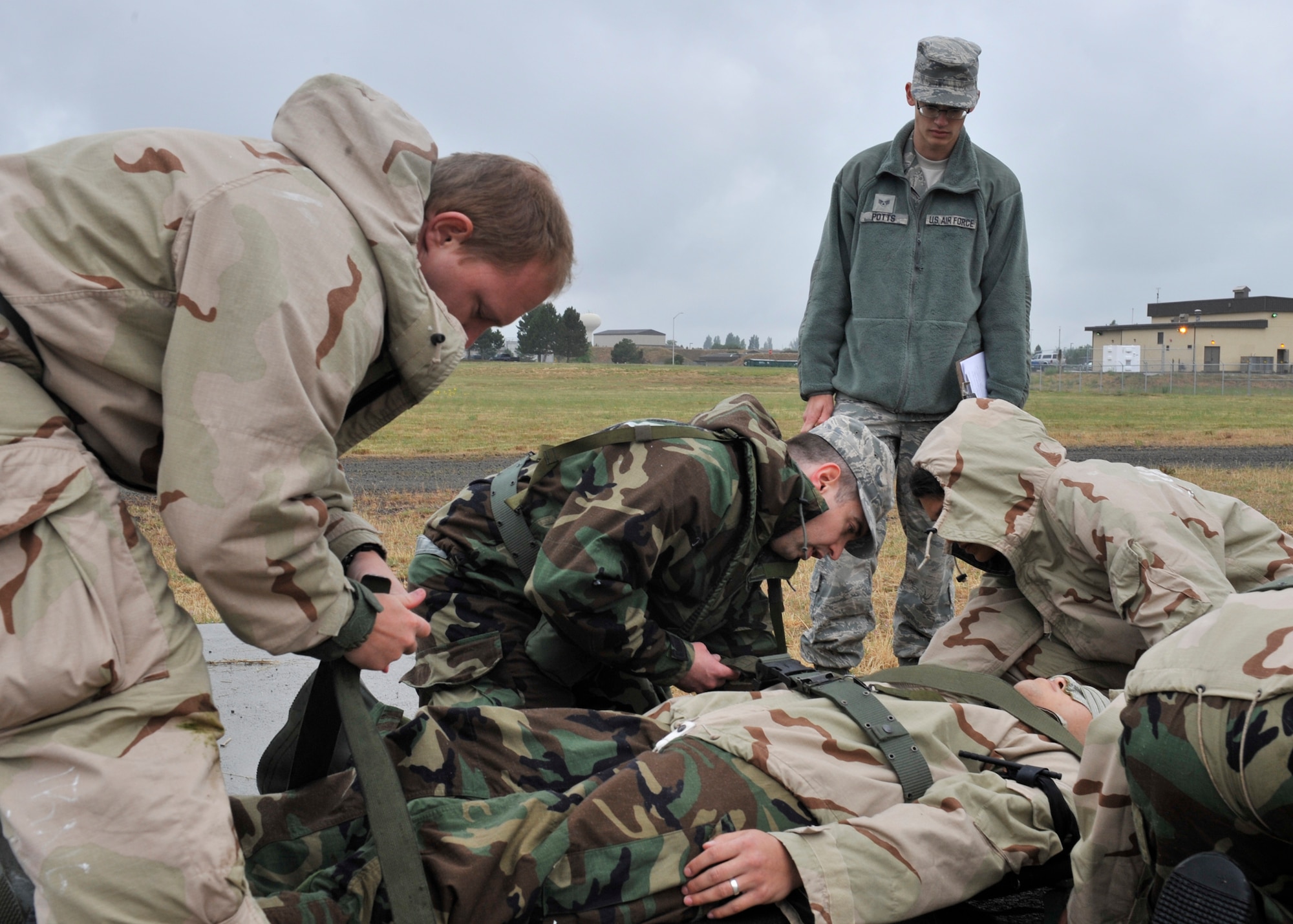 Senior Airman Timothy Potts, 92nd Communications Squadron Self Aid and Buddy Care instructor, instructs members of Team Fairchild the proper way of placing an injured Airman on a litter at Fairchild Air Force Base, Wash. June 20, 2013. (U.S. Air Force photo by Staff Sgt. Michael Means/Released)