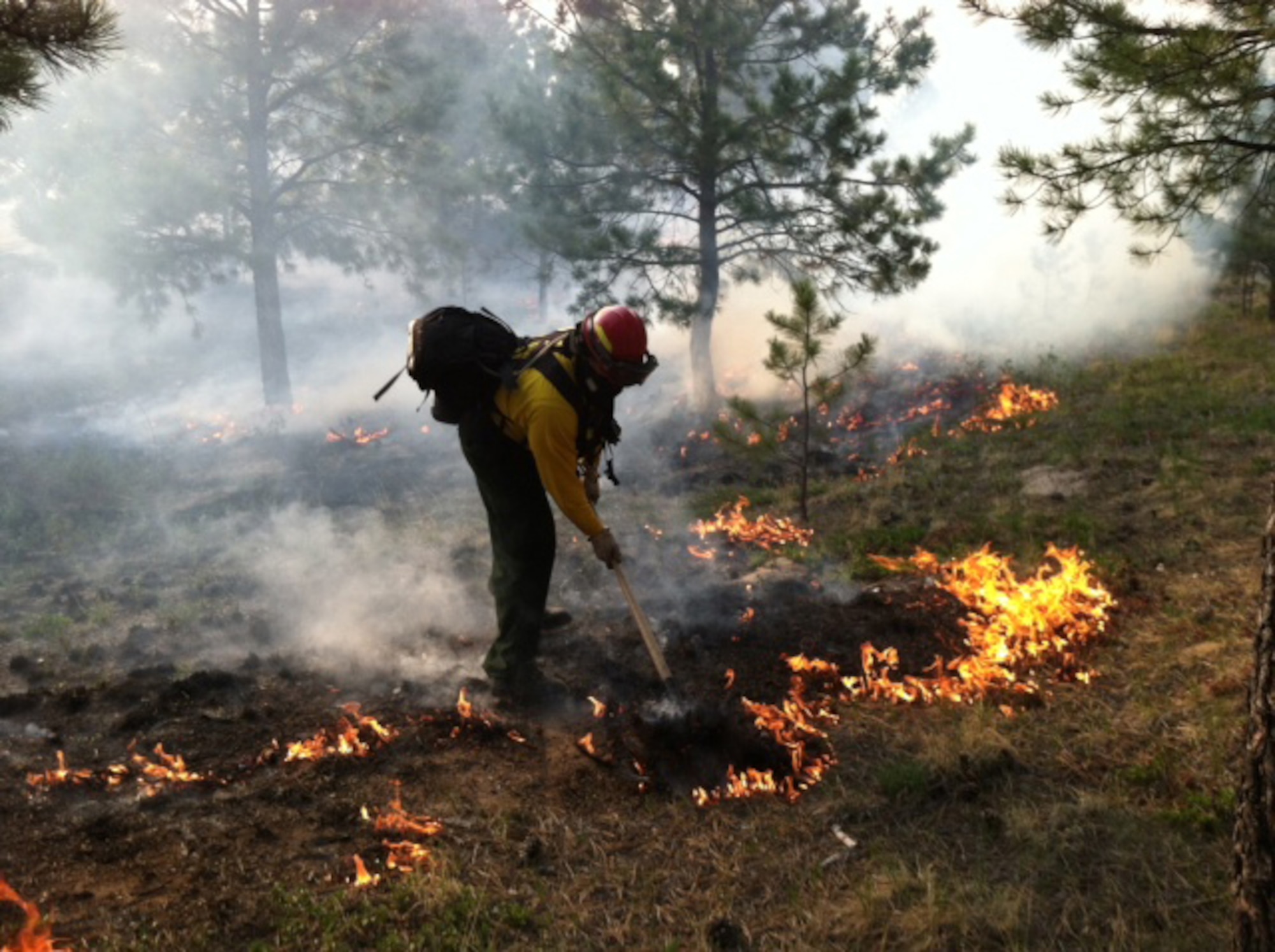A firefighter from the 721st Civil Engineer Squadron fire department at Cheyenne Mountain Air Force Station builds a firebreak to mitigate the raging Black Forest Fire north of Colorado Springs. Firefighters and other emergency service personnel worked around the clock to extinguish the fire that began June 11. Operating under a mutual aid agreement, the CMAFS Fire Department was able to provide specially-trained firefighters within hours. (U.S. Air Force photo)