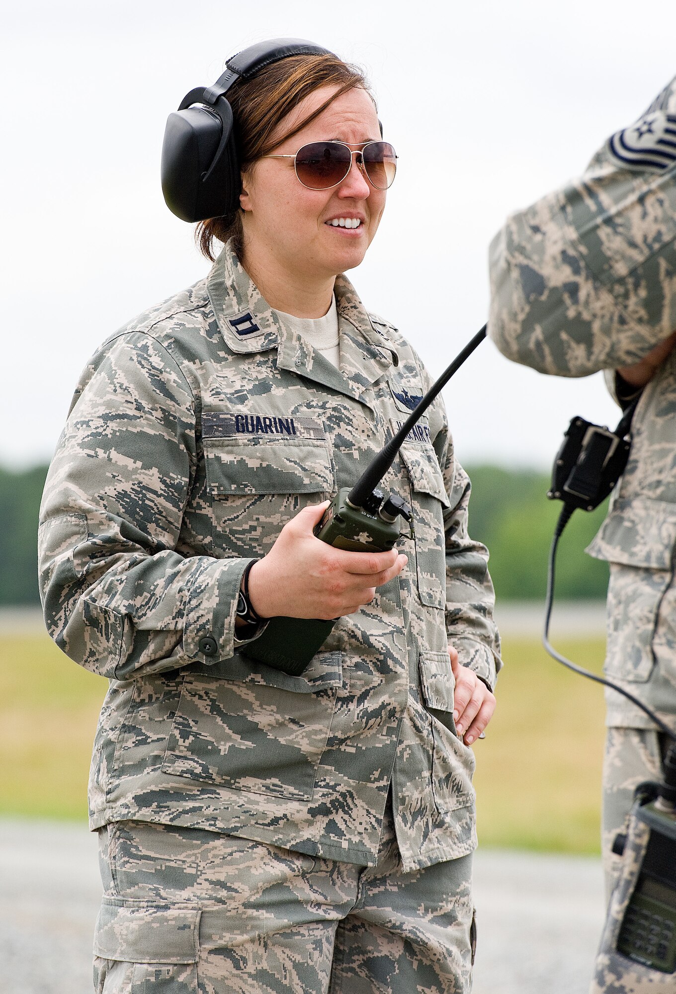 Capt. Jessica Guarini, an Air Mobility Command Phoenix Mobility Officer, 21st Air Mobility Operations Squadron, Joint Base McGuire-Dix-Lakehurst, N.J., listens to the radio during semi-prepared runway operations June 19, 2013 at Fort A.P. Hill, Va. Guarini, a member of the contingency response element, coordinated the take off and landing sequence of a C-17A Globemaster III flown by an aircrew from the 3rd Airlift Squadron, Dover Air Force Base, Del. (U.S. Air Force photo/Roland Balik)
