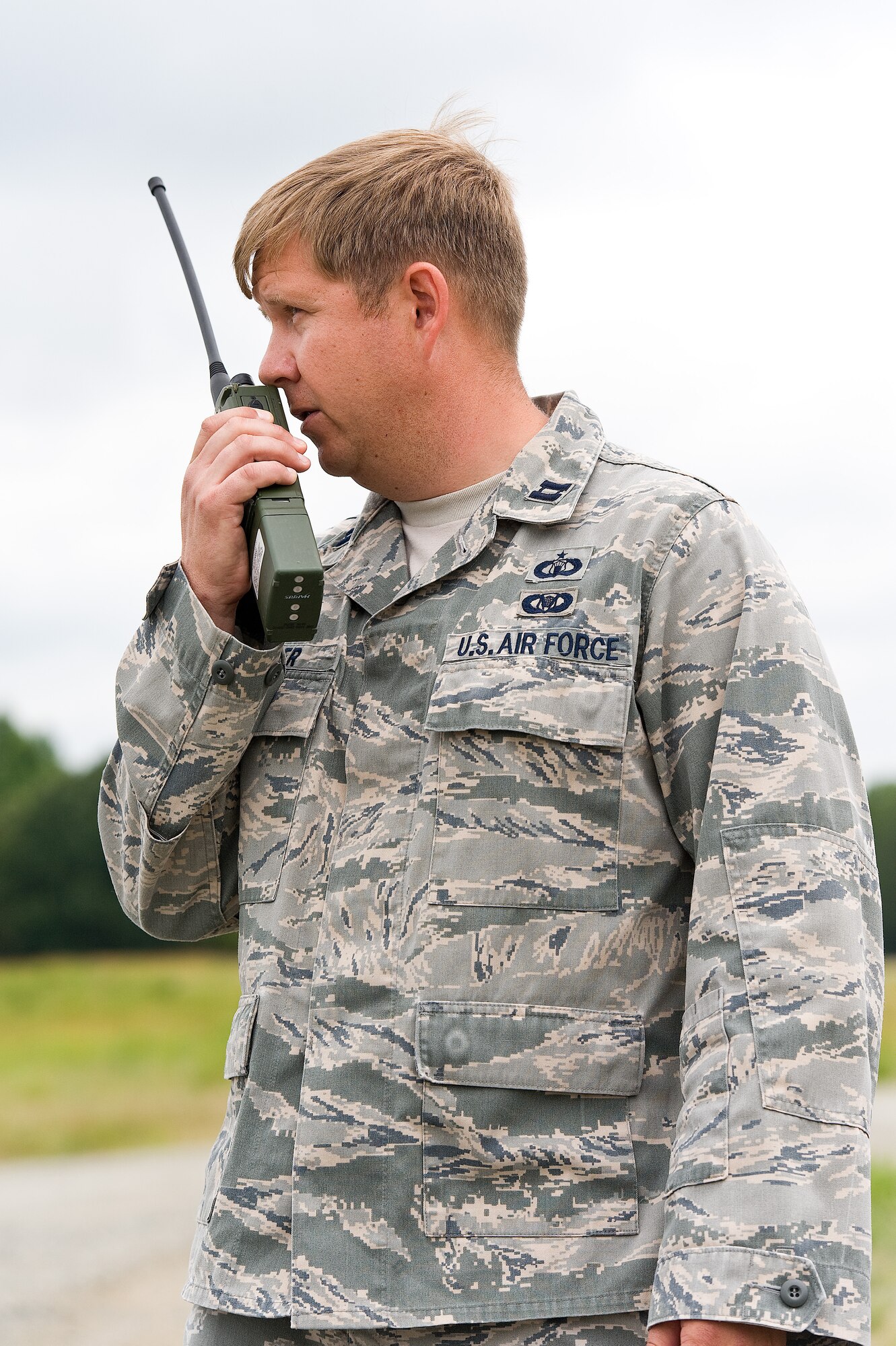 Capt. Paul Cooper, assistant operations officer, 818th Global Mobility Readiness Squadron, Joint Base McGuire-Dix-Lakehurst, N.J., communicates with a C-17A Globemaster III aircrew during semi-prepared runway operations June 19, 2013 at Fort A.P. Hill, Va. The aircrew from the 3rd Airlift Squadron, Dover Air Force Base, Del., practiced landing and take off procedures on the dirt runway. (U.S. Air Force photo/Roland Balik)
