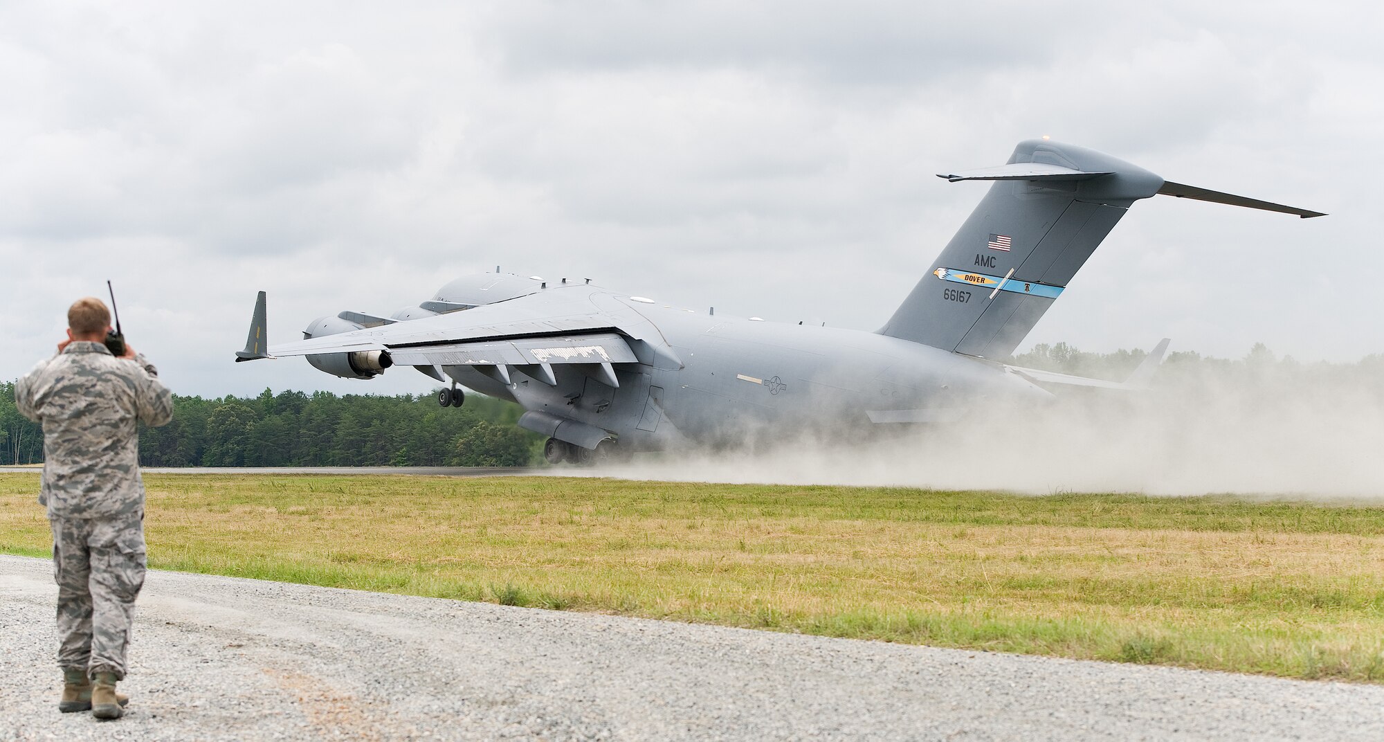 A C-17A Globemaster III flown by an aircrew from the 3rd Airlift Squadron, Dover Air Force Base, Del., takes off June 19, 2013 at Fort A.P. Hill, Va. Capt. Paul Cooper, assistant operations officer, 818th Global Mobility Readiness Squadron, Joint Base McGuire-Dix-Lakehurst, N.J., communicates with the departing aircraft during semi-prepared runway operations. (U.S. Air Force photo/Roland Balik)