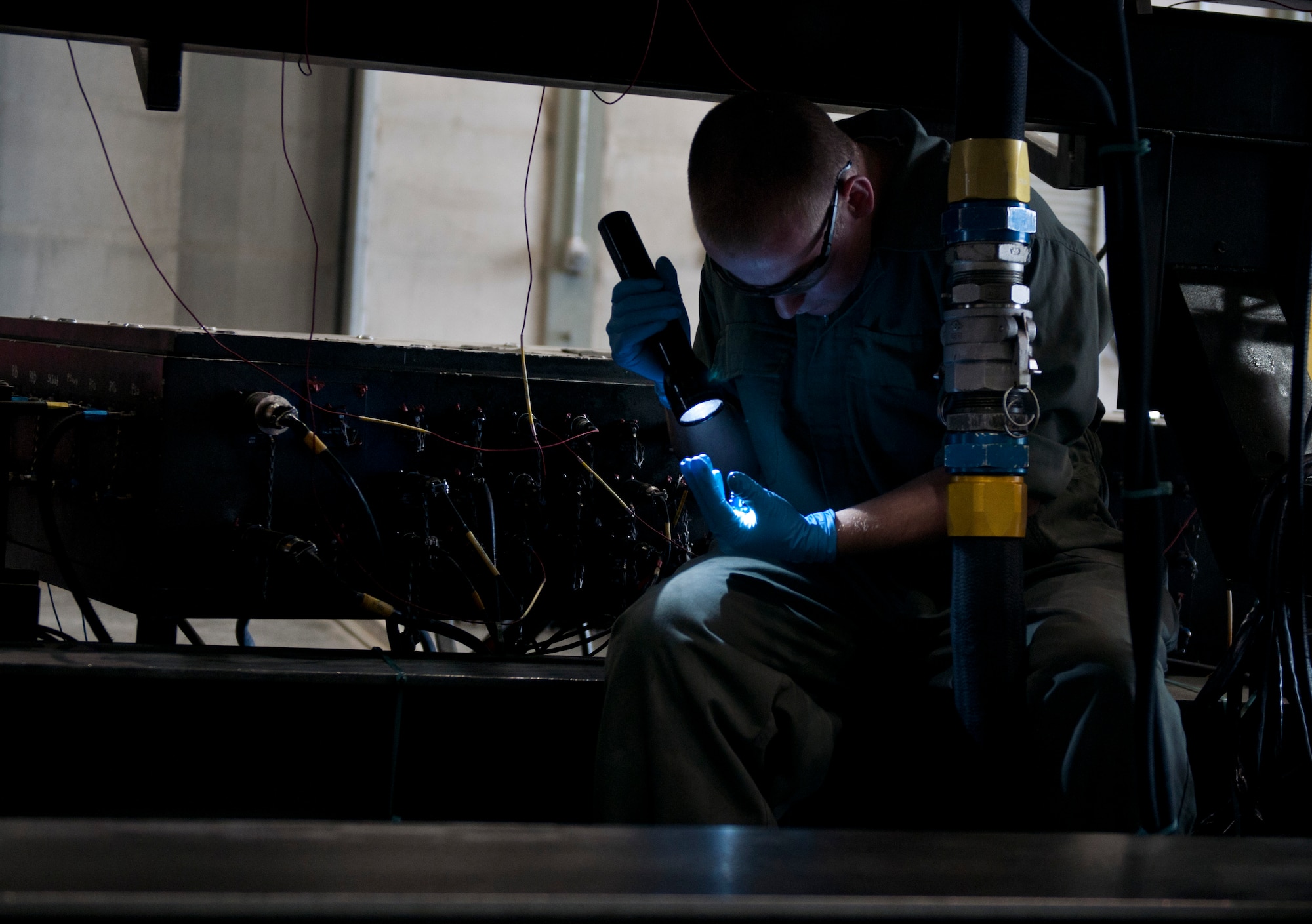 U.S. Air Force Airman 1st Class Ryan Barron, 366th Component Maintenance Squadron aerospace propulsion apprentice, uses his flashlight to check an F-15E Strike Eagle engine part, May 5, 2013, at Mountain Home Air Force Base, Idaho. All engine components must be checked prior to and after an engine test run. (U.S. Air Force photo by Senior Airman Heather Hayward/Released)