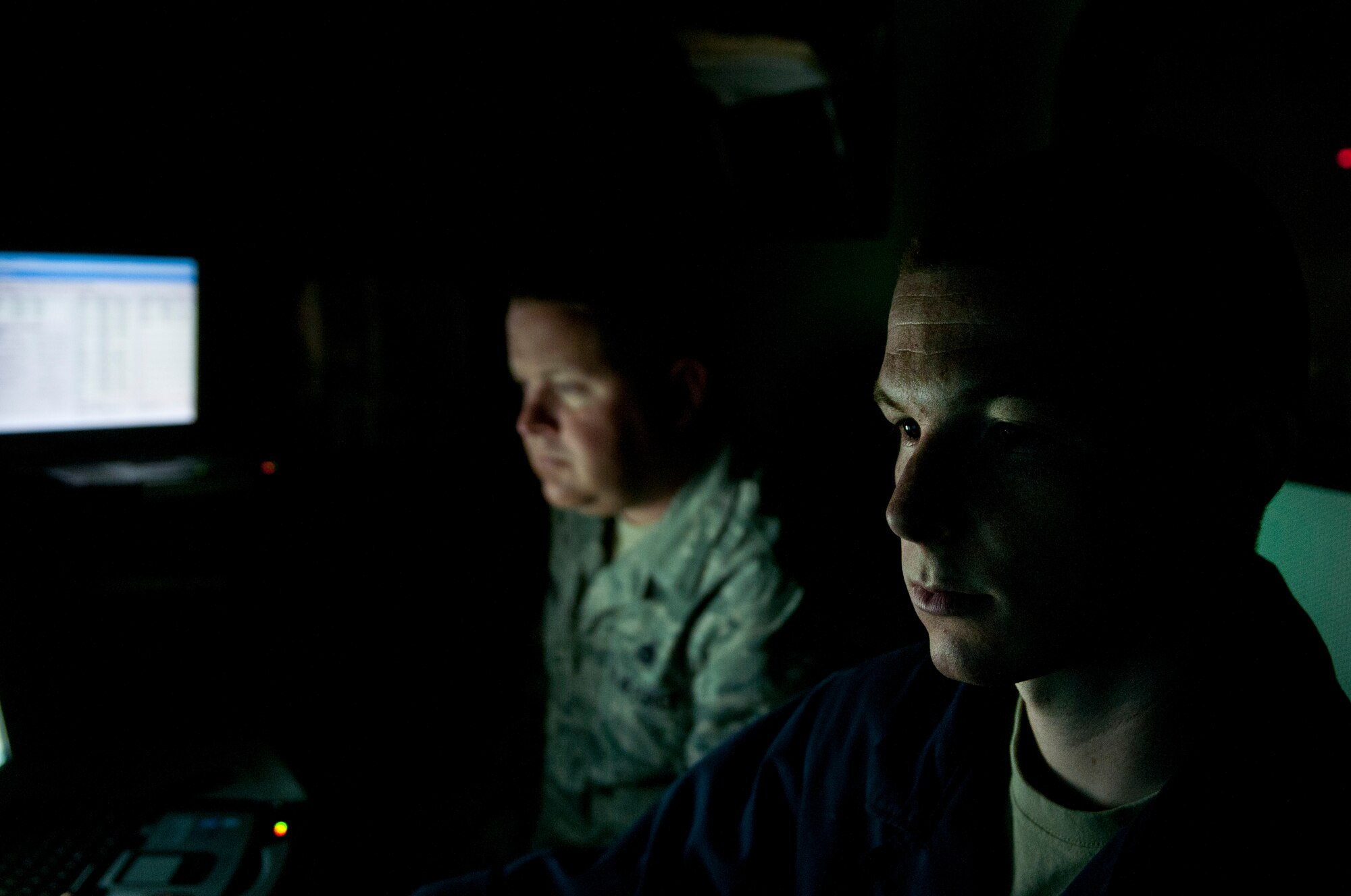 U.S. Air Force Staff Sgt. Jesse Howey, 366th Component Maintenance Squadron aerospace propulsion craftsman, and Master Sgt. Chad Jacobsen, engine test cell section chief, looks at a computer during an engine test run, May 5, 2013, at Mountain Home Air Force Base, Idaho. There are three groups of people in different areas completing different tasks, but all work together to ensure the safety of an F-15E Strike Eagle engine. (U.S. Air Force photo by Senior Airman Heather Hayward/Released)