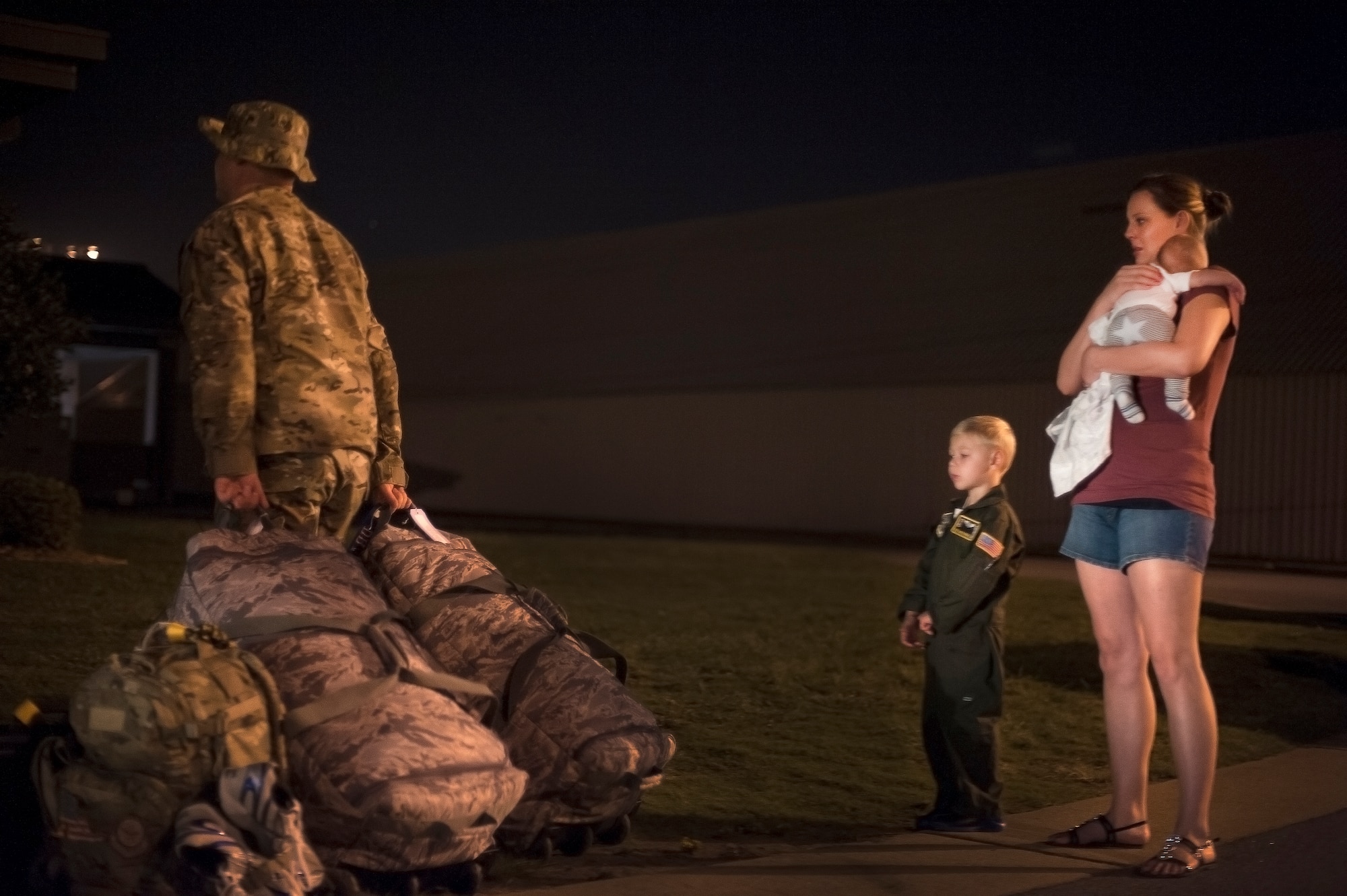 Tech. Sgt. Aaron Drain walks away, after saying goodbye to his family Sept. 4, 2012, at Little Rock Air Force Base, Ark. Drain would spend the next five months deployed to Afghanistan, providing tactical airlift to the area of responsibility. (U.S. Air Force photo by Staff Sgt. Russ Scalf)