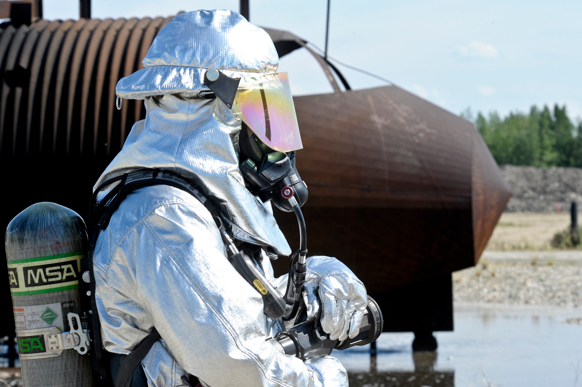 An Iceman firefighter awaits live-fire training on an aircraft fire trainer June 20, 2013, Eielson Air Force Base, Alaska. Firefighters with the 354th Civil Engineer Squadron perform live-fire training to stay prepared for potential fire hazards. (U.S. Air Force photo by Senior Airman Zachary Perras/Released)