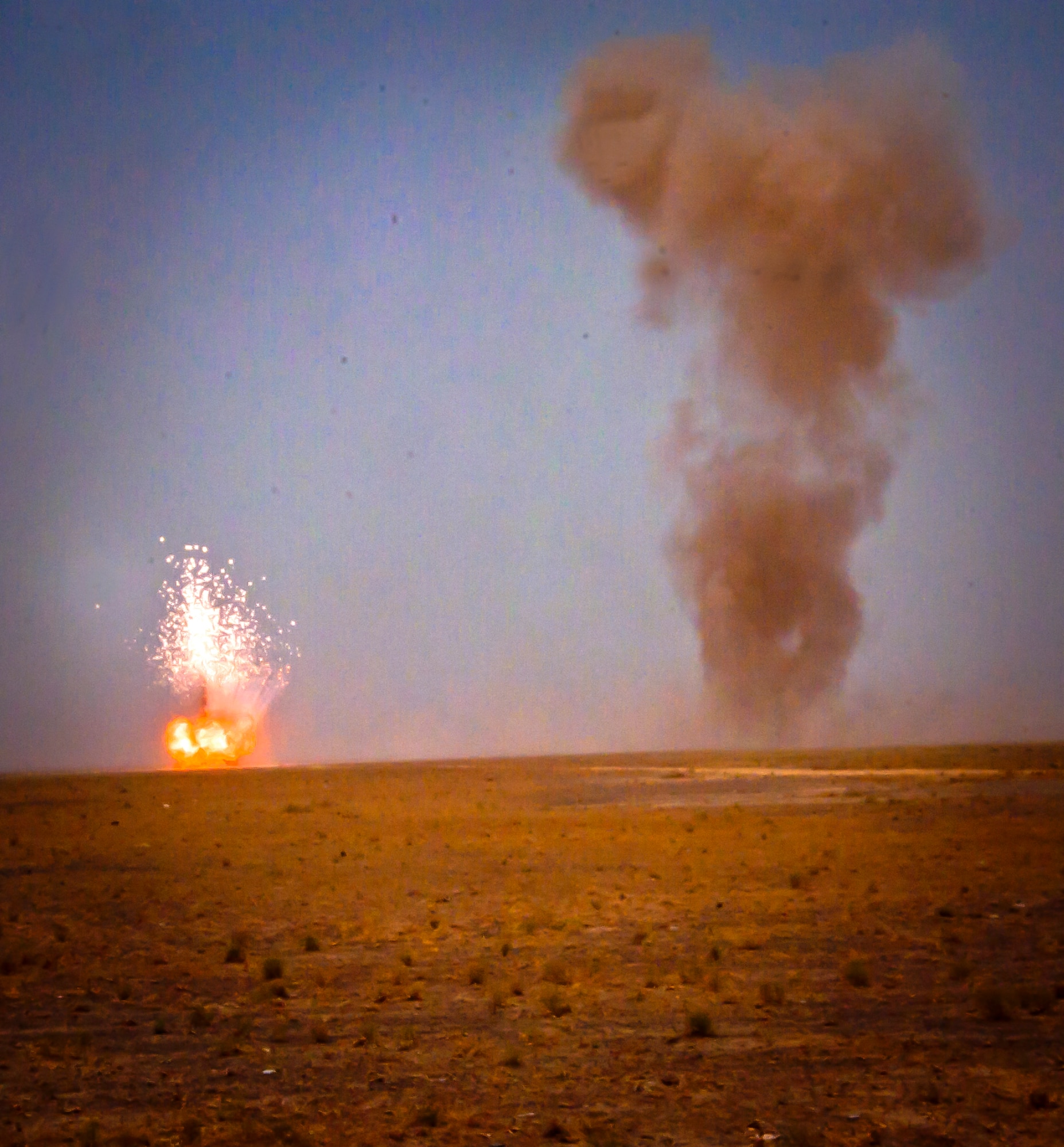 Smoke rises and controlled detonations go off during a joint-coalition mission near Kandahar Airfield, Afghanistan, June 12, 2013. Romanian soldiers provided security for the mission while U.S. Air Force, U.S. Army, Slovakian and Australian explosive ordnance disposal personnel conducted the controlled detonations, which was an example of the working partnerships between the allied countries. (U.S. Air Force photo/Senior Airman Scott Saldukas)