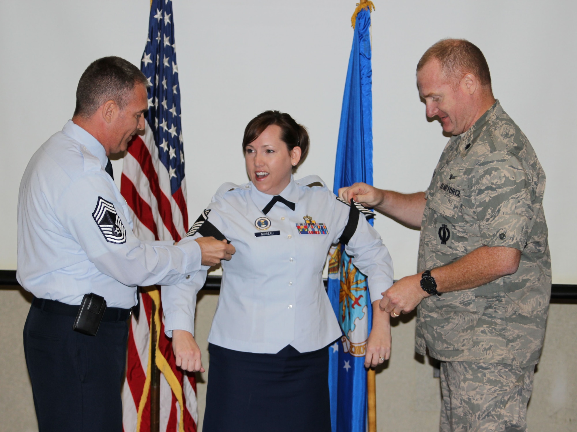 Tech. Sgt. Charly Moreau, 318th Recruiting Squadron health professions recruiter (center), is promoted to master sergeant in a surprise presentation during the 311th RCS change of command at Canonsburg, Pa., June 12. Lt. Col. Timothy Cox, 318th RCS commander (right), and Chief Master Sgt. Brad Buening, 360th Recruiting Group superintendent, presented Moreau with her new rank. (U.S. Air Force photo)