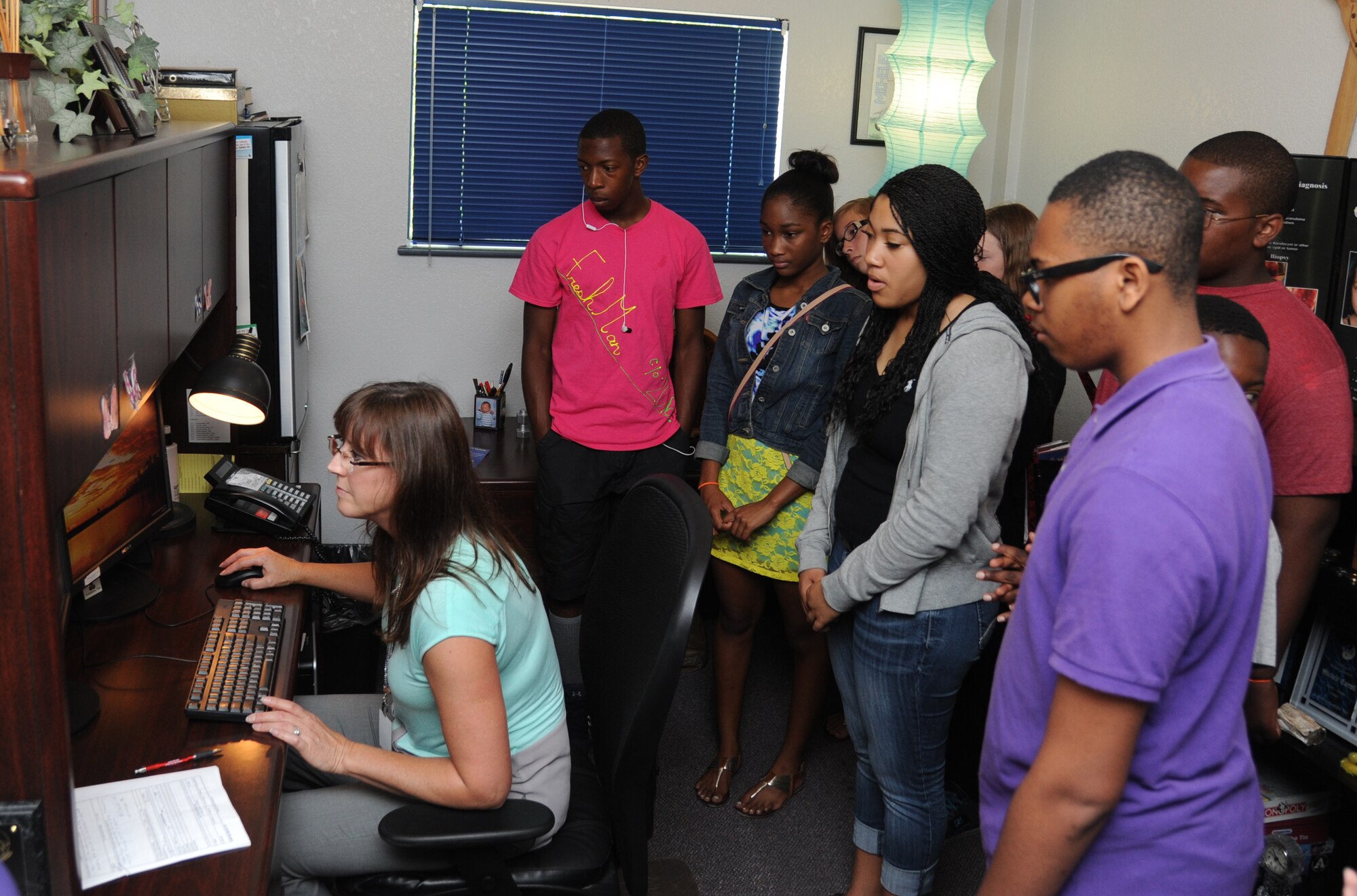 Michele Keller, K-Mar Industries contract illustrator, provides a computer graphics demonstration to children from the youth center June 21, 2013, at Wall Studio, Keesler Air Force Base, Miss.  The youth center teen summer camp program also toured the public affairs office and other visual information services such as photo, video, graphics.  (U.S. Air Force photo by Kemberly Groue)
