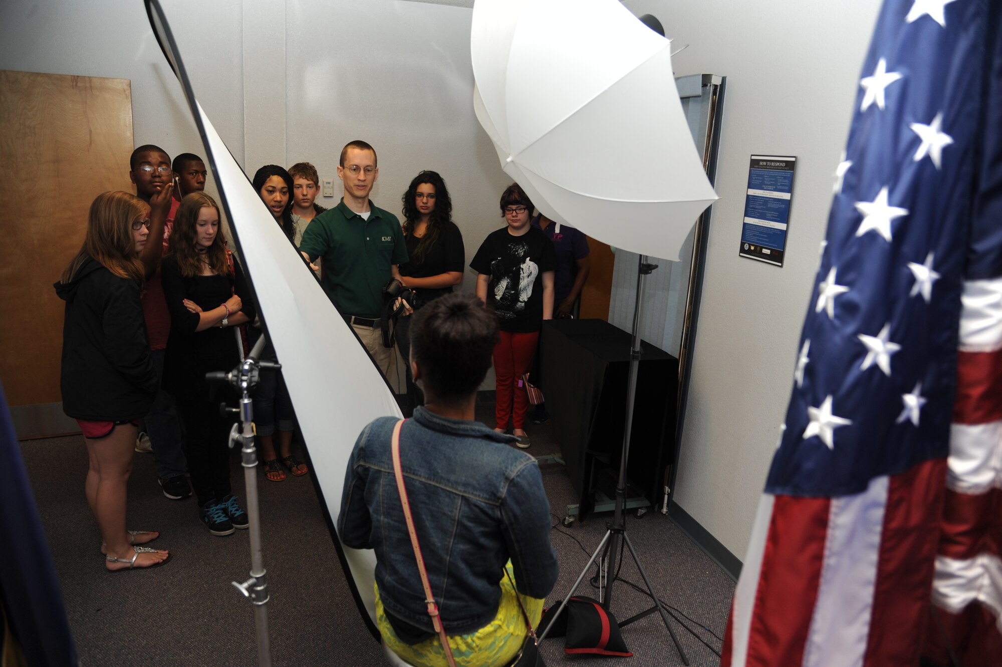 Adam Bond, K-Mar Industries contract photographer, shows official photo samples inside the studio to children from the youth center June 21, 2013, at Wall Studio, Keesler Air Force Base, Miss.  The youth center teen summer camp program also toured the public affairs office and other visual information services such as photo, video, graphics.  (U.S. Air Force photo by Kemberly Groue)