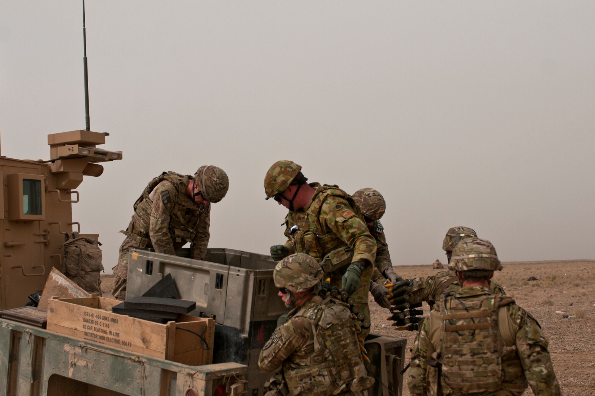 U.S. Army, U.S. Air Force and Australian explosive ordnance disposal technicians unload munitions to prepare for a controlled detonation outside of Kandahar Airfield, Afghanistan, June 12, 2013. U.S. Army, U.S. Air Force, Australian and Slovakian EOD personnel worked to dispose of excess military ordnance while Romanian soldiers provided security for the joint mission, an example of the working partnerships among the allied forces here. (U.S. Air Force photo/Capt. Brian Maguire)