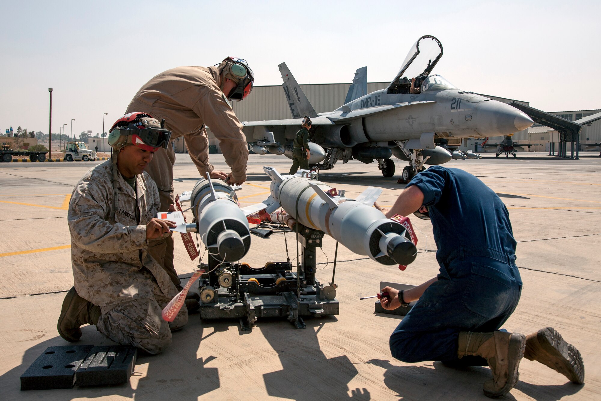 Marines from the VMFA-115 squadron attach fins on Joint Direct Attack Munitions that will be placed on an F-18 aircraft, like the one pictured, for exercise missions during the Eager Lion exercise. The Marine Fighter Attack squadron is operating out of a training base in Northern Jordan. Eager Lion is a U.S. Central Command-directed, irregular warfare-themed exercise focusing on missions the United States and its coalition partners might perform in support of global contingency operations. (U.S. Air National Guard photo by Senior Master Sgt. John P. Rohrer)