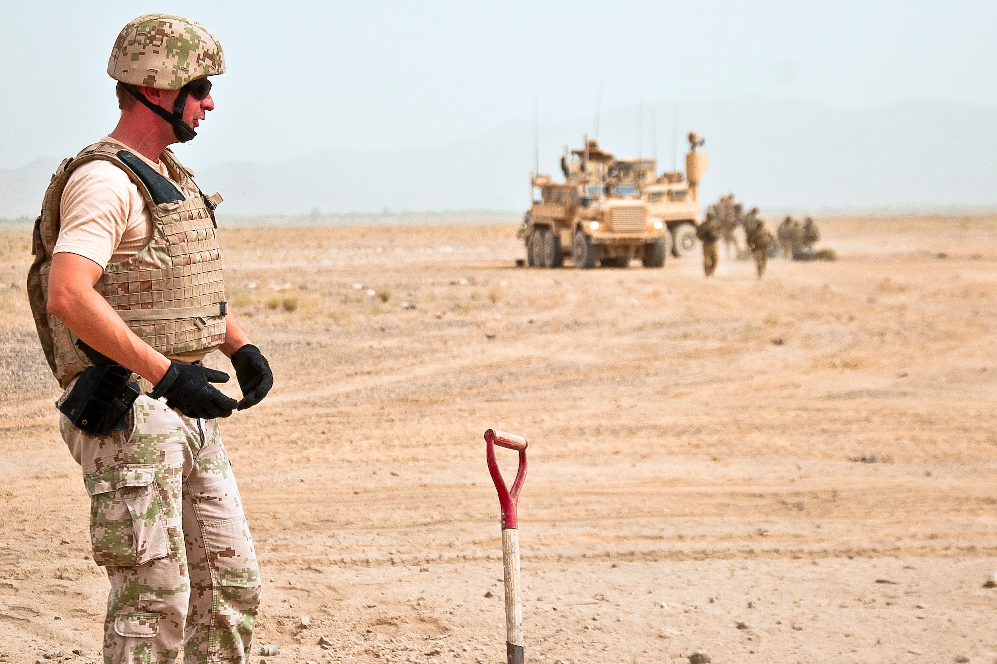 A Slovakian explosive ordnance disposal soldier observes a controlled detonation location near Kandahar Airfield, Afghanistan, June 12, 2013. With Romanian soldiers providing security, U.S. Air Force, U.S. Army, Slovakian and Australian EOD personnel conducted a joint mission to dispose of excess military ordnance. (U.S. Air Force photo/Senior Airman Scott Saldukas)
