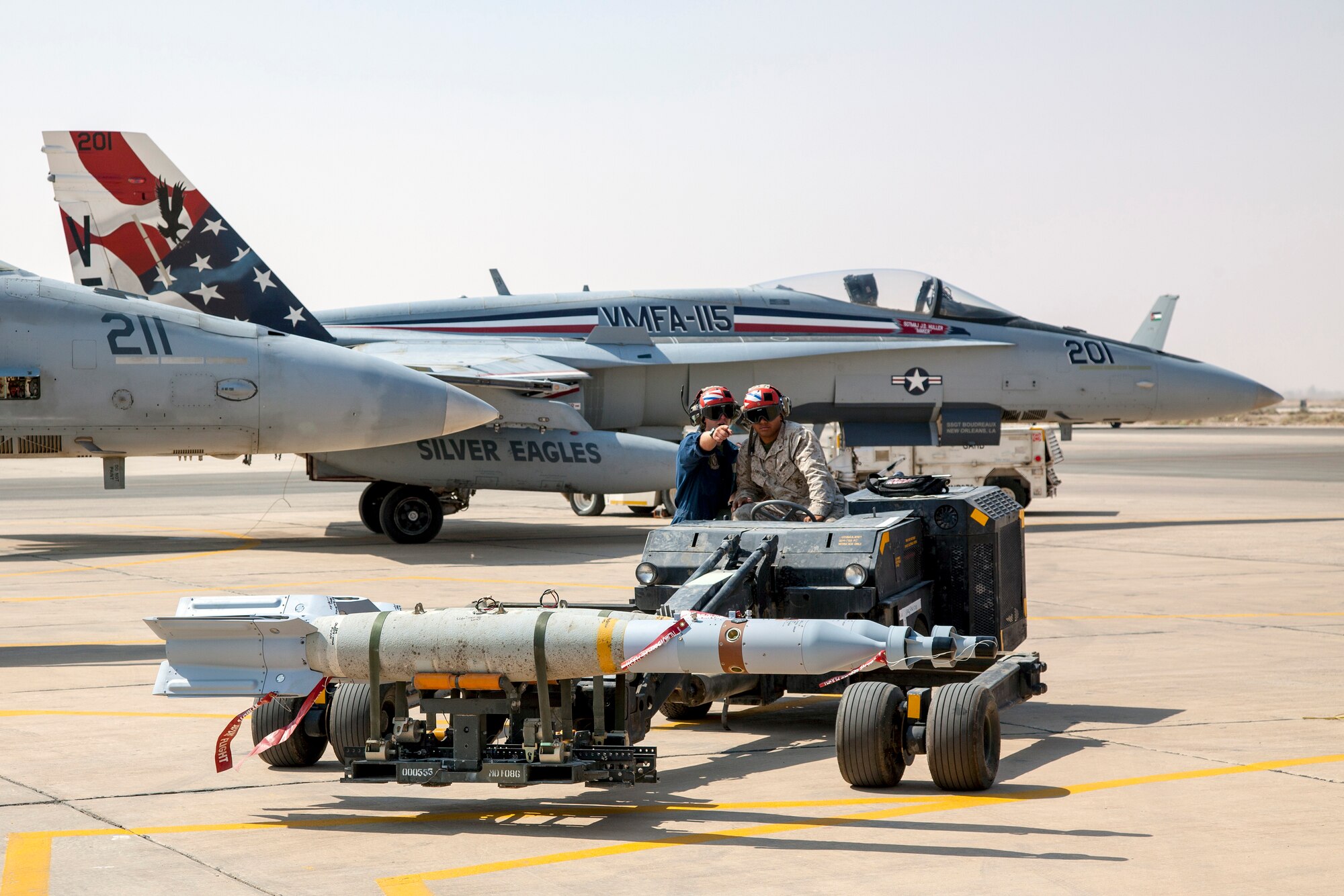 Two Marines from the VMFA-115 squadron set bombs in place that will be used on the F-18 aircraft pictured here. The Marine Fighter Attack squadron is operating out of a training base in Northern Jordan and is performing close air support missions in conjunction with joint tactical air controllers as part of the Eager Lion exercise. Eager Lion is a U.S. Central Command-directed, irregular warfare-themed exercise focusing on missions the United States and its coalition partners might perform in support of global contingency operations. (U.S. Air National Guard photo by Senior Master Sgt. John P. Rohrer)