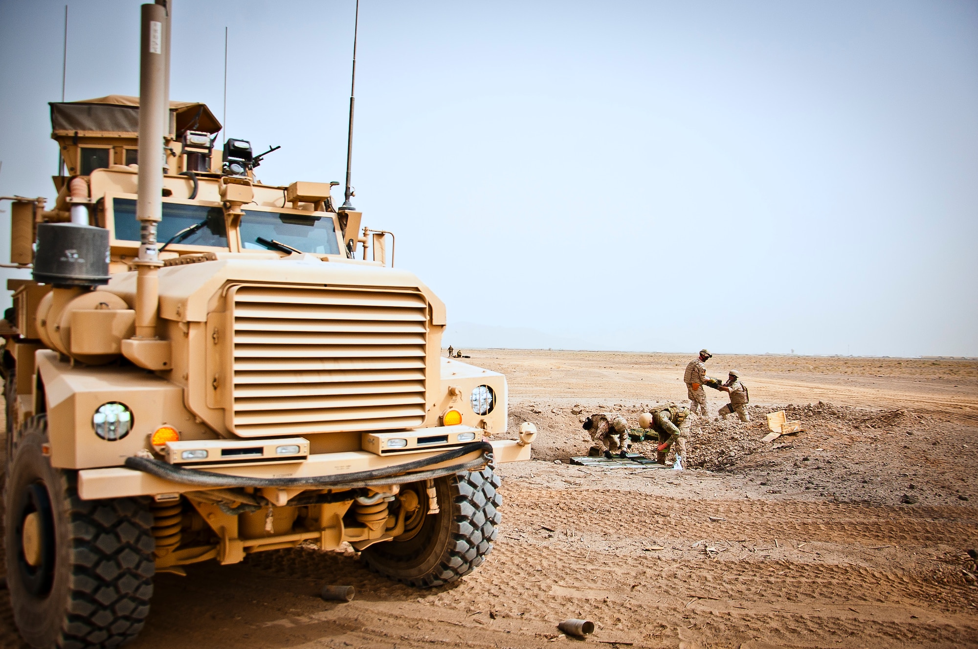 U.S. Air Force and Slovakian explosive ordnance disposal personnel unload a trailer and carefully place ordnance for a controlled detonation near Kandahar Airfield, Afghanistan, June 12, 2013. U.S. Air Force, U.S. Army, Slovakian and Australian EOD personnel participated in a joint mission to dispose of excess military ordnance. (U.S. Air Force photo/Senior Airman Scott Saldukas)