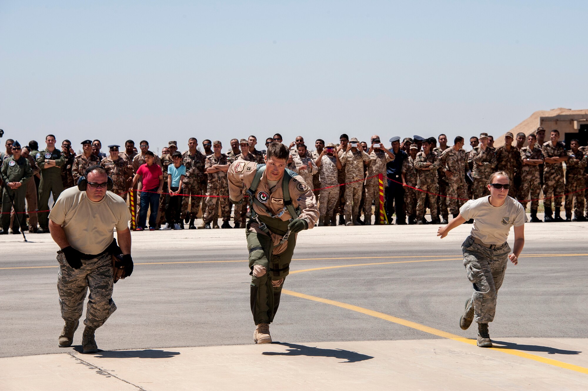 Capt.James Edwards, a pilot with the 120th Fighter Squadron, and his crew chiefs Tech Sgt. Joshua Matthews and Senior Airman Kristen Lee, run to launch an F-16 Fighting Falcon as part of a scramble competition event between the Colorado Air National Guard and the Royal Jordanian Air Force. The Scramble tests the pilots and their crew chiefs in their ability to launch aircraft in a simulated quick response scenario during Eager Lion. Eager Lion is a U.S. Central Command-directed, irregular warfare-themed exercise focusing on missions the United States and its coalition partners might perform in support of global contingency operations. (U.S. Air National Guard photo by Senior Master Sgt. John P. Rohrer)