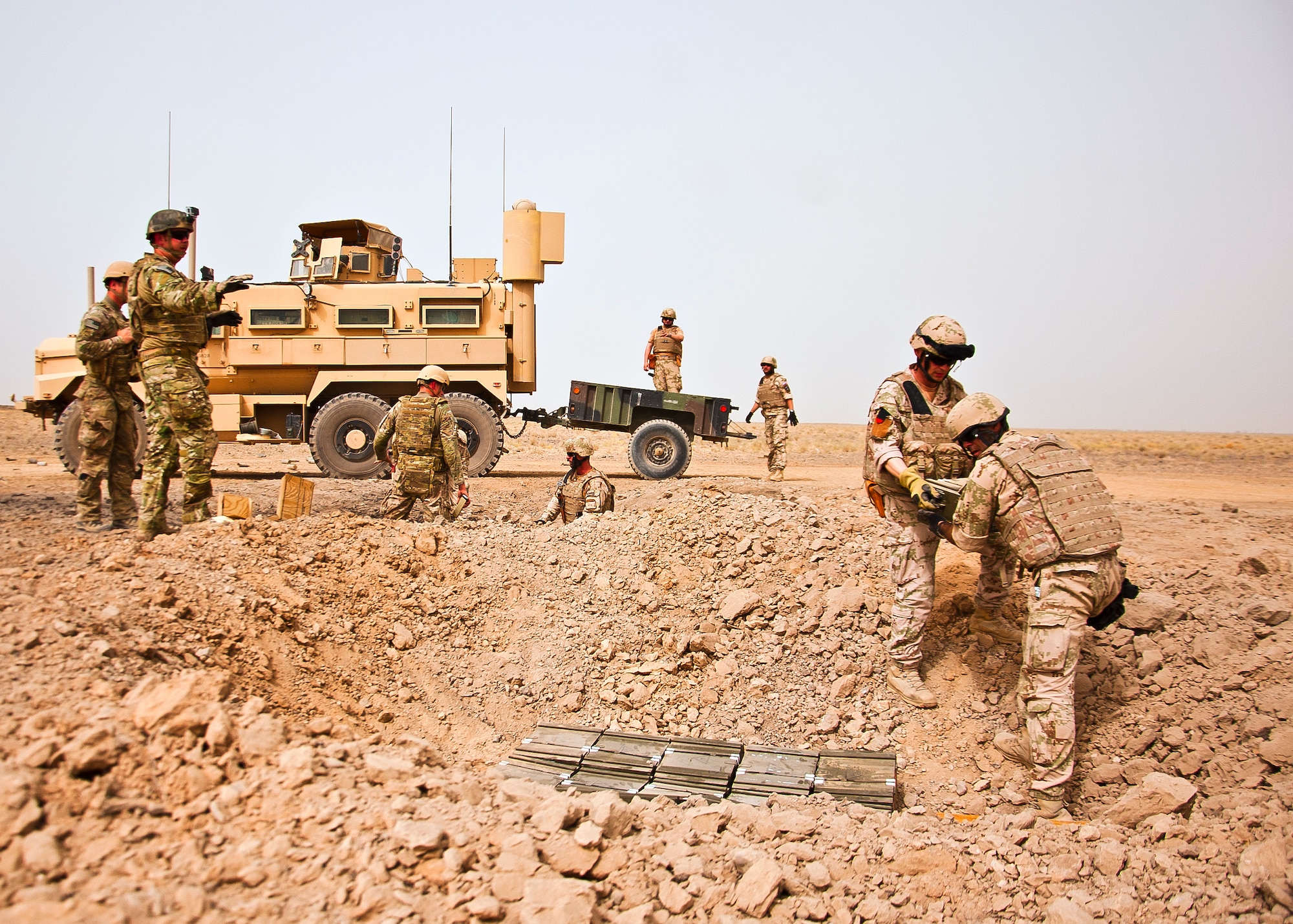 U.S. Air Force and Slovakian explosive ordnance disposal personnel unload a trailer and carefully place ordnance for a controlled detonation near Kandahar Airfield, Afghanistan, June 12, 2013. U.S. Air Force, U.S. Army, Slovakian and Australian EOD personnel participated in a joint mission to dispose of excess military ordnance. (U.S. Air Force photo/Senior Airman Scott Saldukas)