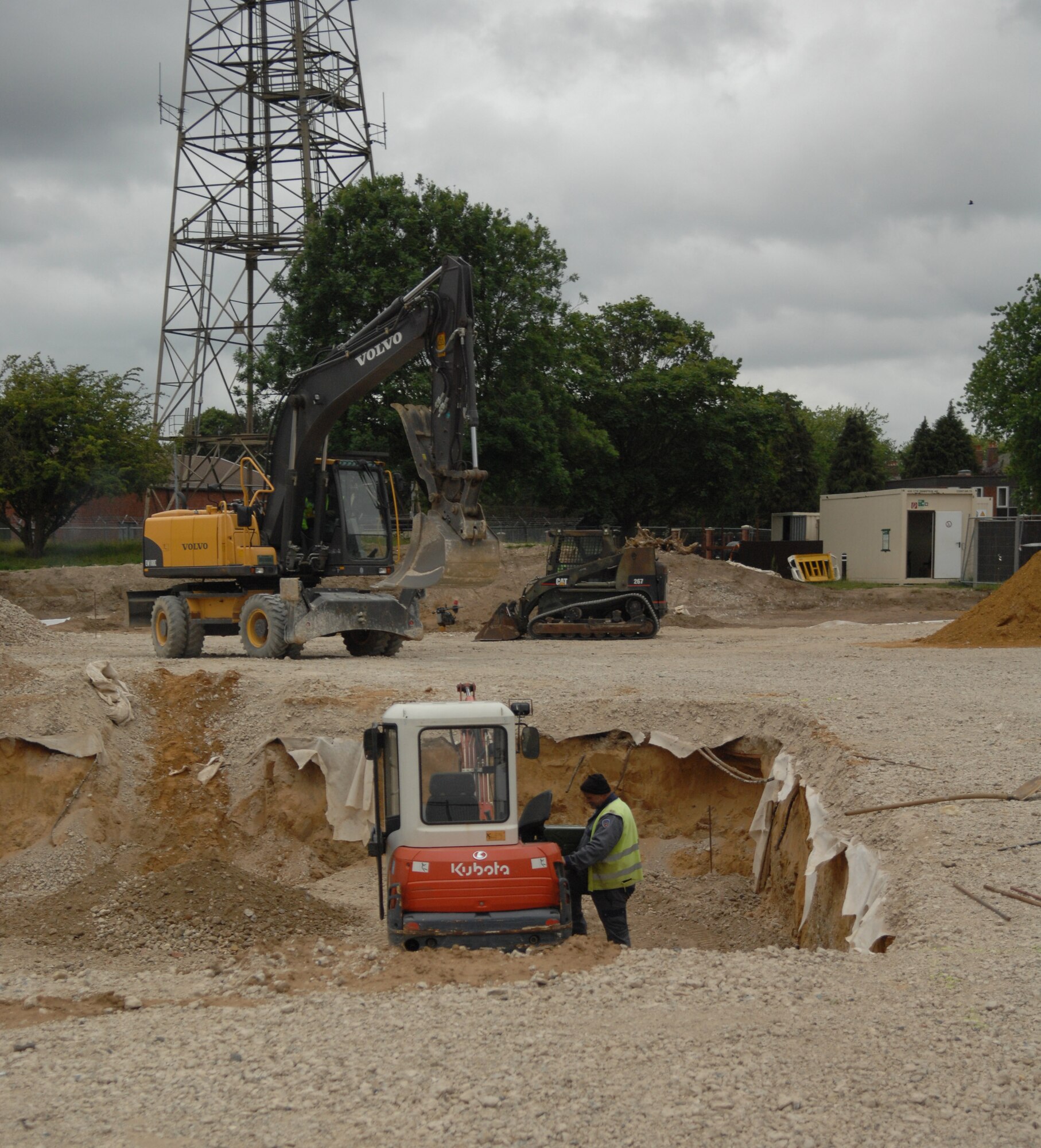 Construction workers continue work on a parking lot behind building 591 June 24, 2013, on RAF Mildenhall, England. Construction started February 2013, and is slated to finish July 2013. The parking lot’s capacity will hold 75 vehicles, giving building 591 staff more parking as building occupancy increases. (U.S. Air Force photo by Airman 1st Class Dillon Johnston/Released)