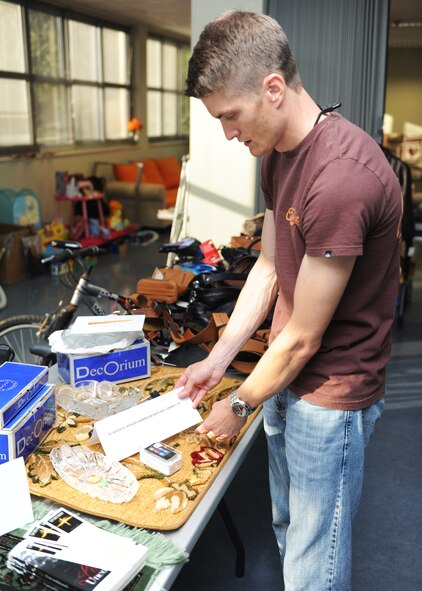 Capt. Dave Stuckenberg, deployed to Incirlik Air Base, arranges items for the Rummage for Relief fundraiser June 7, 2013 at Incirlik Air Base, Turkey. Turkish shop owners, Team Incirlik, private organizations and the Army and Air Force Exchange Service poured out donations and support for the disaster relief fundraiser. (U.S. Air Force photo by Senior Airman Chase Hedrick/Released)