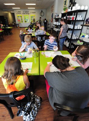 Airmen and dependents paint pottery during a Hearts Apart event at the Chartreuse Moose in Warrensburg, Mo., June 17, 2013. Sponsored by the Airman & Family Readiness Center, the Hearts Apart program provides an opportunity for military dependents to participate in various activities and connect with other individuals who are going through similar situations. (U.S. Air Force photo by Staff Sgt. Nick Wilson/Released) 