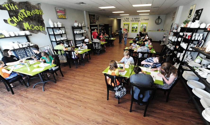 Airmen and dependents paint pottery during a Hearts Apart event at the Chartreuse Moose in Warrensburg, Mo., June 17, 2013. Hearts Apart is a morale-building program for spouses and dependents of military members who are currently deployed, on an extended temporary duty assignment or serving a remote tour. (U.S. Air Force photo by Staff Sgt. Nick Wilson/Released)