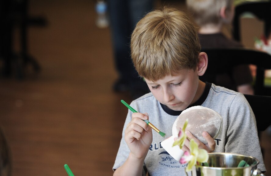 A child paints pottery during a Hearts Apart event at the Chartreuse Moose in Warrensburg, Mo., June 17, 2013. Hearts Apart is a monthly program the Airman and Family Readiness Center uses to help build resiliency in family members by offering fun events for military spouses and dependents. (U.S. Air Force photo by Staff Sgt. Nick Wilson/Released)