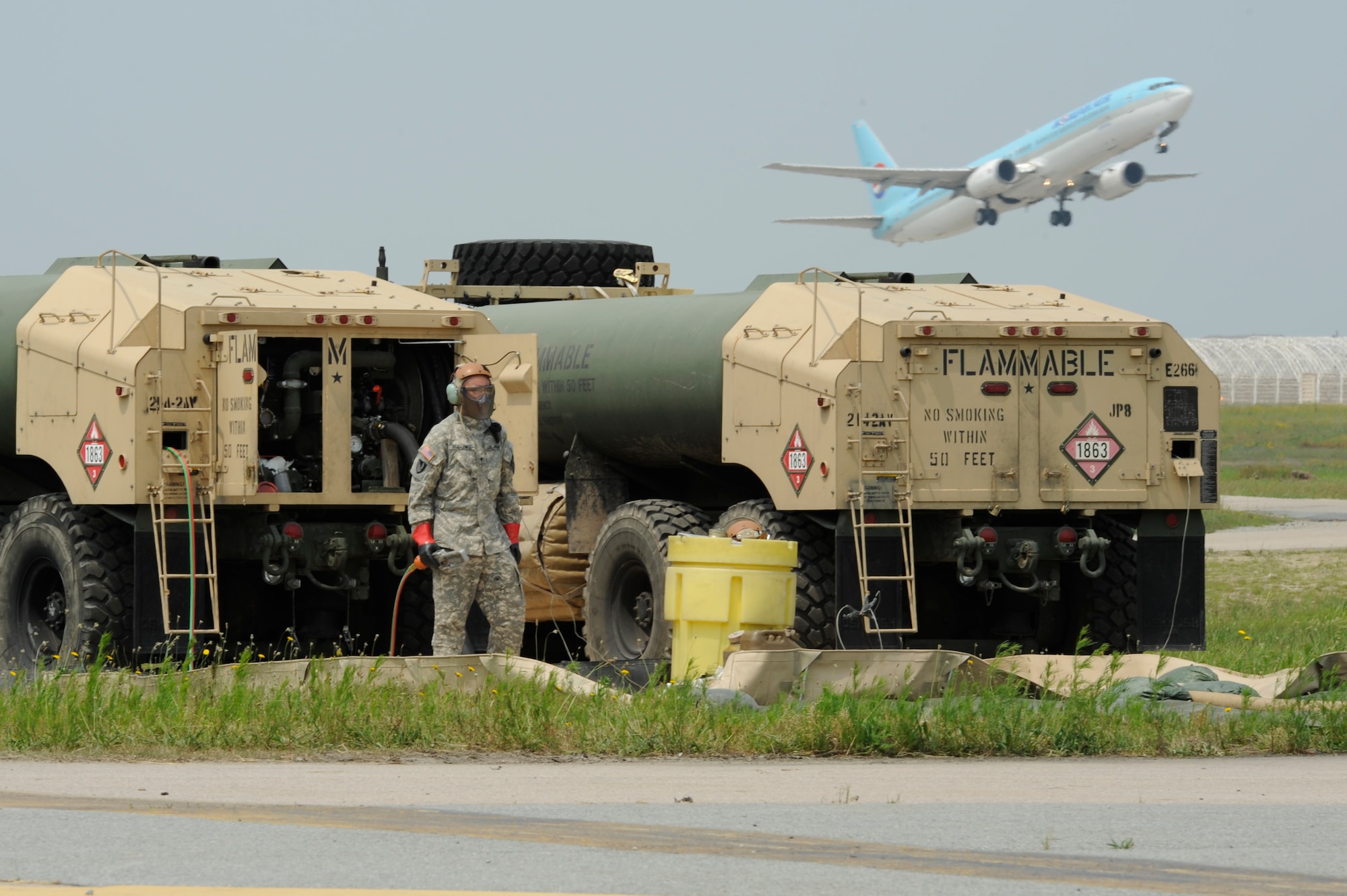 A U.S. Army fueler, Spc. Miguel Rojo-Lemke, Echo Company, 4th Aerial Reconnaissance Battalion (Attack), 2nd Aviation Regiment, 92-F petroleum supply specialist, Camp Humphreys, Republic of Korea, controls a dead man switch while dispensing JP-8 fuel for helicopters, at Kunsan Air Base, ROK, June 7, 2013. Rojo-Lemke provided 12 helicopters with fuel support for a week-long, live-fire training exercise at Jik-Do Island, near Kunsan. (U.S. Air Force photo/ Staff Sgt. Tong Duong/ Released)  
