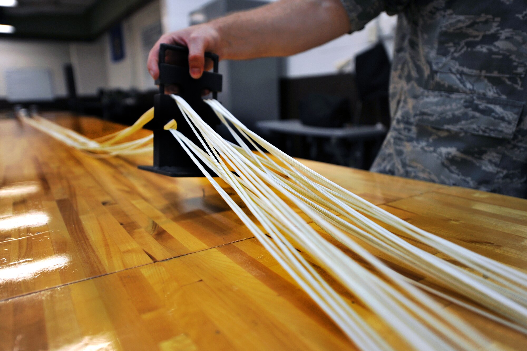 Staff Sgt. Ronald Johnson, 51st Operations Support Squadron aircrew flight equipment parachute section NCO in charge, checks suspension-line separation during a routine maintenance parachute packing at Osan Air Base, Republic of Korea, June 24, 2013. Johnson is responsible for checking the technician’s work by performing periodic inspections during the packing process. (U.S. Air Force photo/Senior Airman Alexis Siekert)
