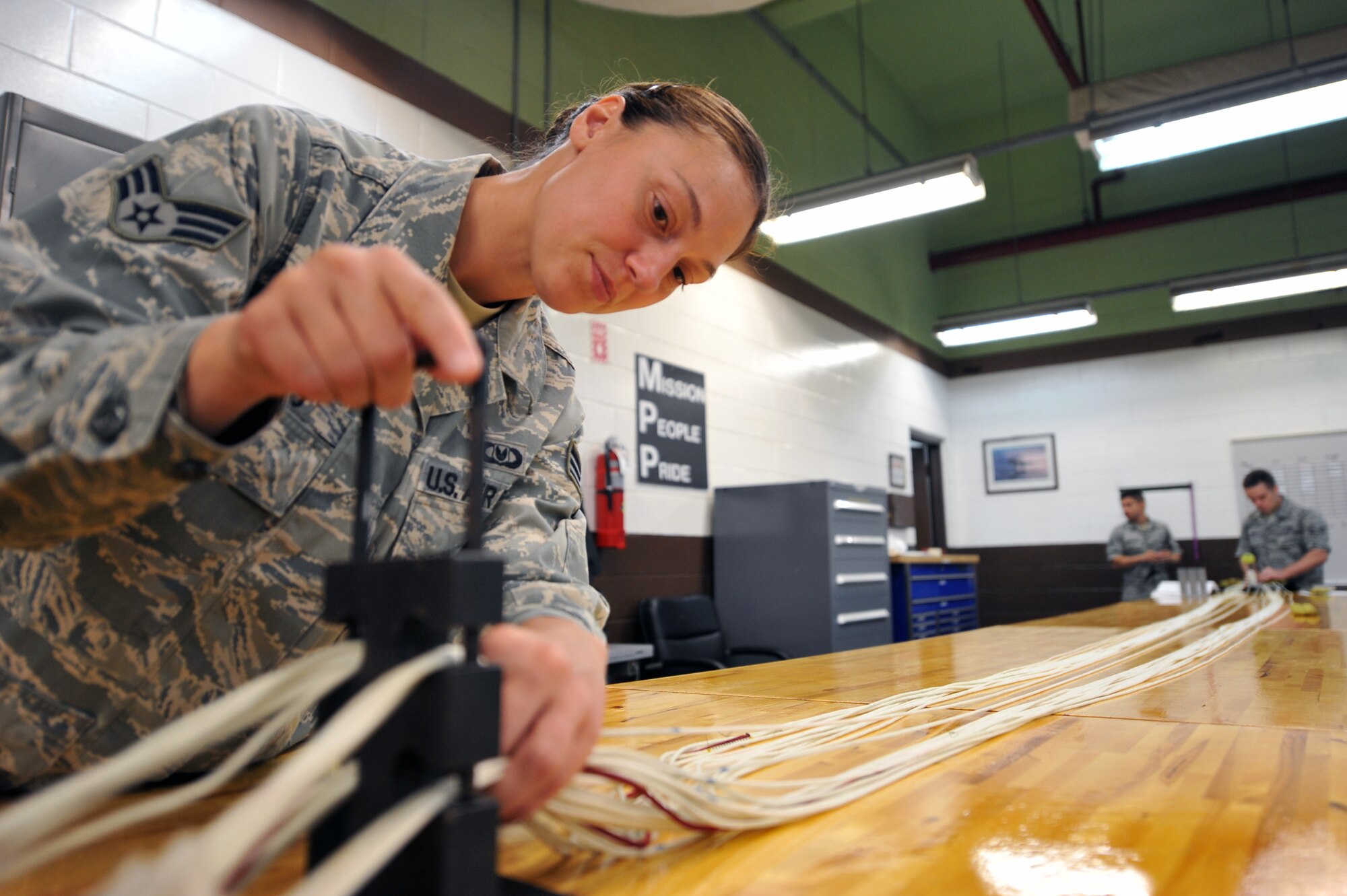 Senior Airman Kristi Seeds, 51st Operations Support Squadron aircrew flight equipment journeyman, inserts a suspension-line separator during a routine maintenance parachute packing at Osan Air Base, Republic of Korea, June 24, 2013. AFE maintains more than 100 parachutes on Osan as well as performs maintenance on deceleration, or drag parachutes for Republic of Korea Air Force aircraft when needed. (U.S. Air Force photo/Senior Airman Alexis Siekert)