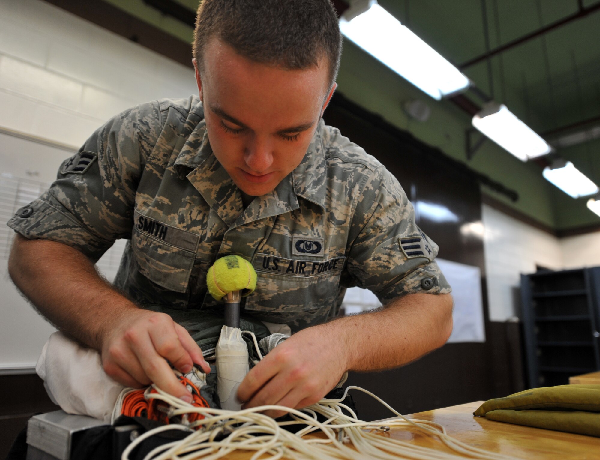 Senior Airman Taylor Smith, 51st Operations Support Squadron aircrew flight equipment journeyman, packs an Advanced Concept Ejection Seat II recovery parachute during a routine maintenance packing at Osan Air Base, Republic of Korea, June 24, 2013. Each parachute is inspected and repacked annually to ensure they are still operating correctly to ensure pilot safety. (U.S. Air Force photo/Senior Airman Alexis Siekert)
