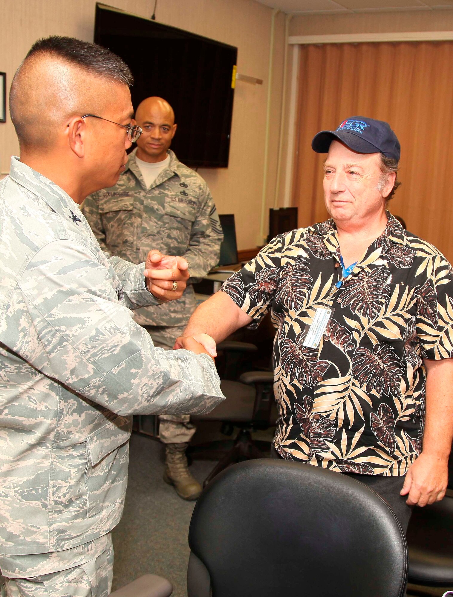 The commander of the 624th Regional Support Group, Col. Maynard "Max" Mendoza, left, shakes hands with Thomas Borgioli, right, the civilian employer of reservist Senior Airman Tara Marino (not pictured) of the 624th Aeromedical Staging Squadron, Joint Base Pearl Harbor-Hickam, Hawaii, June 8, 2013. Marino nominated Borgioli, her boss at the U.S. Army Health Clinic Medical Laboratory, for a Patriot Award for his support of her and two other 624th ASTS reservists who work for him at the lab. Marino said Borgioli, a U.S. Army veteran, received his "40 Years of Exceptional Service" medal from the DoD in 2011 and is an awesome supporter of the U.S. Air Force Reserves! (U.S. Air Force photo by Staff Sgt. Rashard Coaxum)